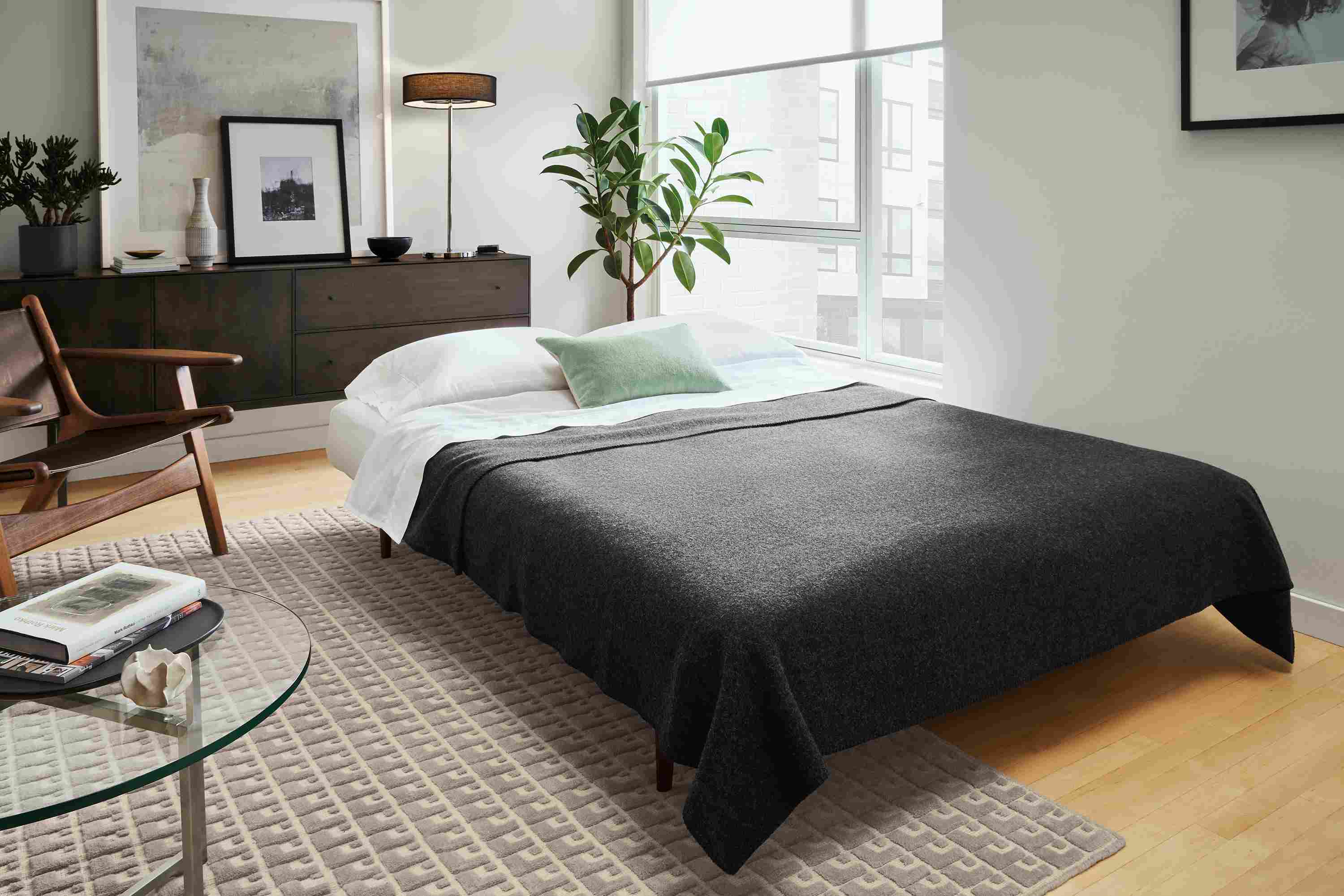 Living room with Deco 79 wide Armless convertible sleeper sofa in Ula Grey shown opened as a bed.