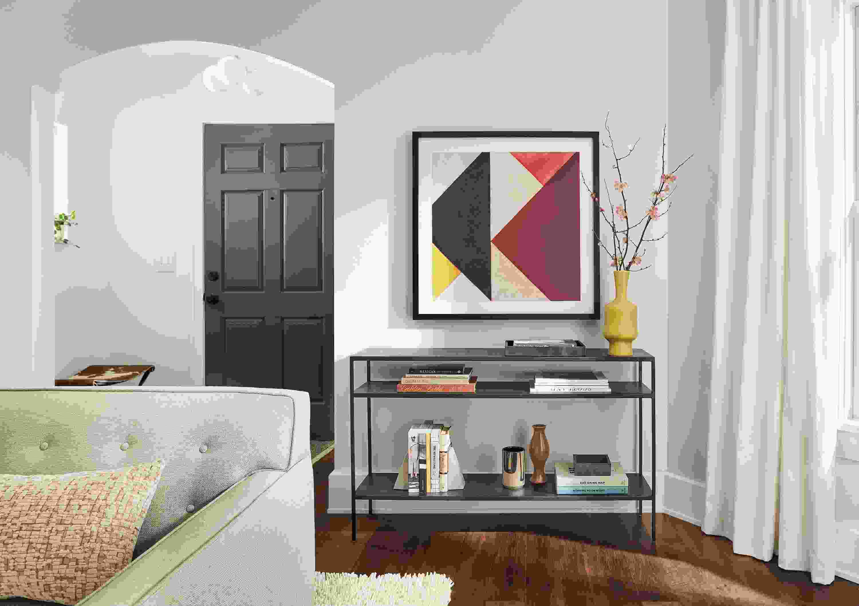 Living area with Slim 48-wide Console Table in Natural Steel with Theo Van Doesburg Artwork hanging on wall above.