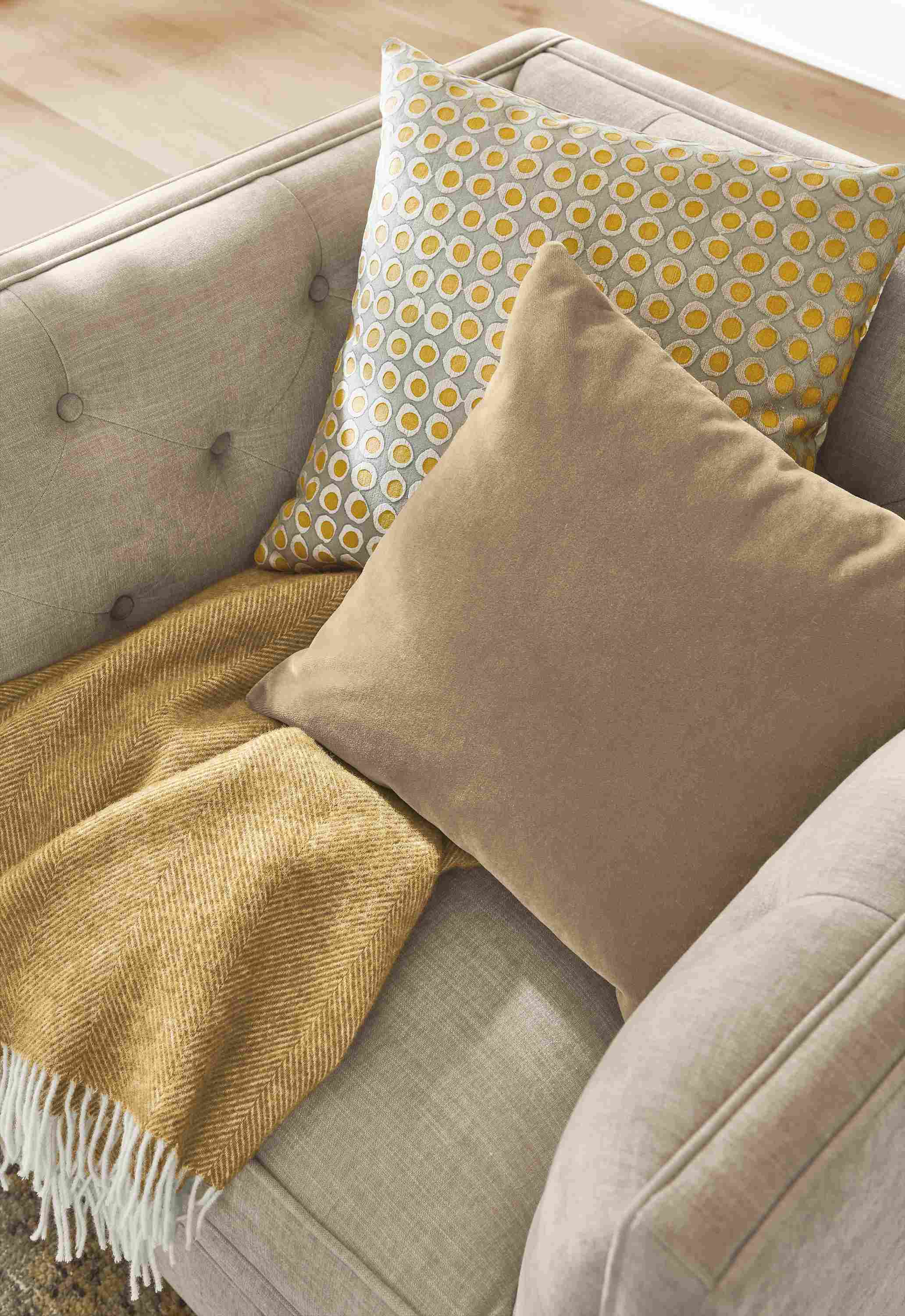 Close-up of Mohair pillow, dot pillow and Claridge throw on Macalester swivel chair.