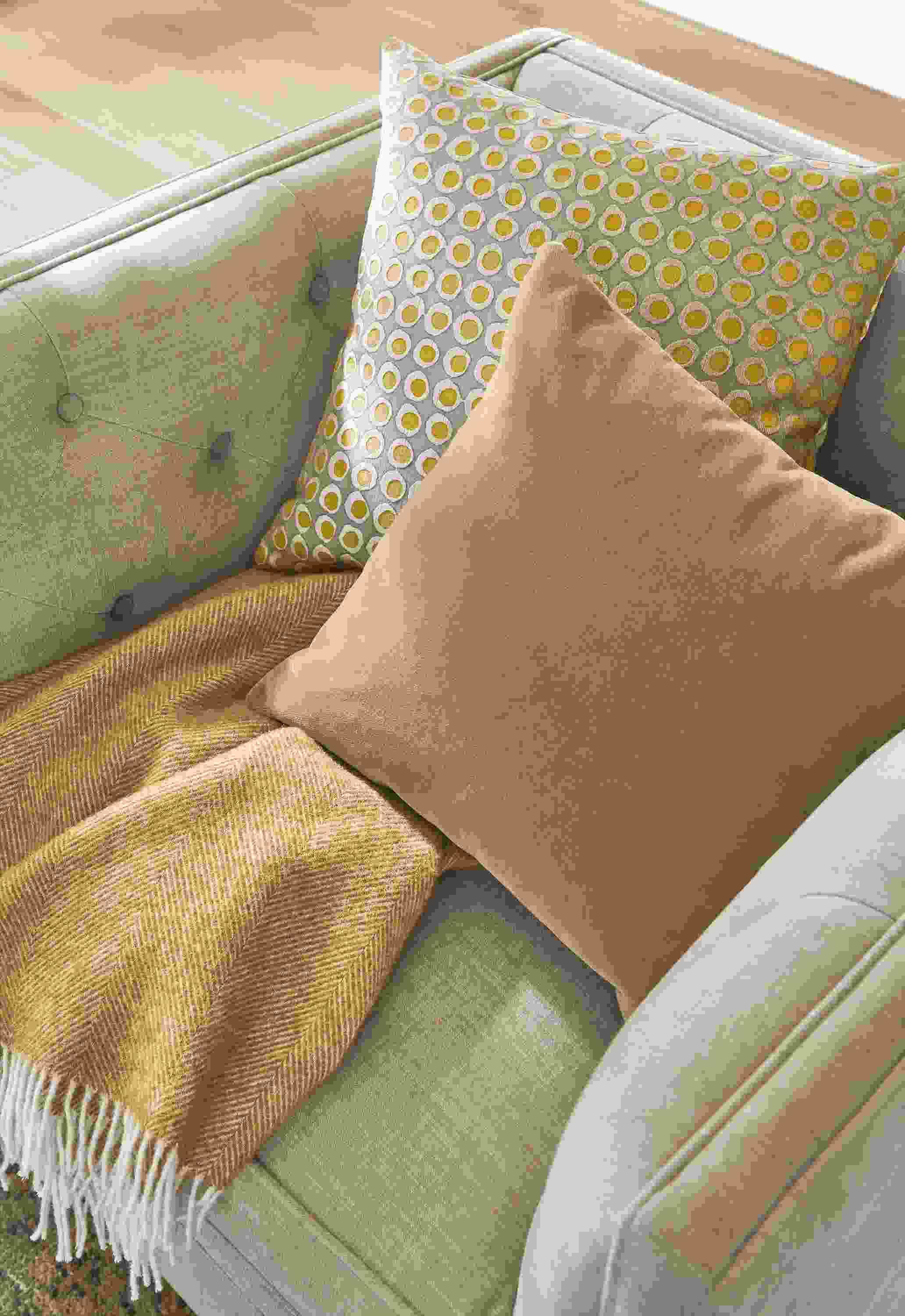 Close-up of Mohair pillow, dot pillow and Claridge throw on Macalester swivel chair.