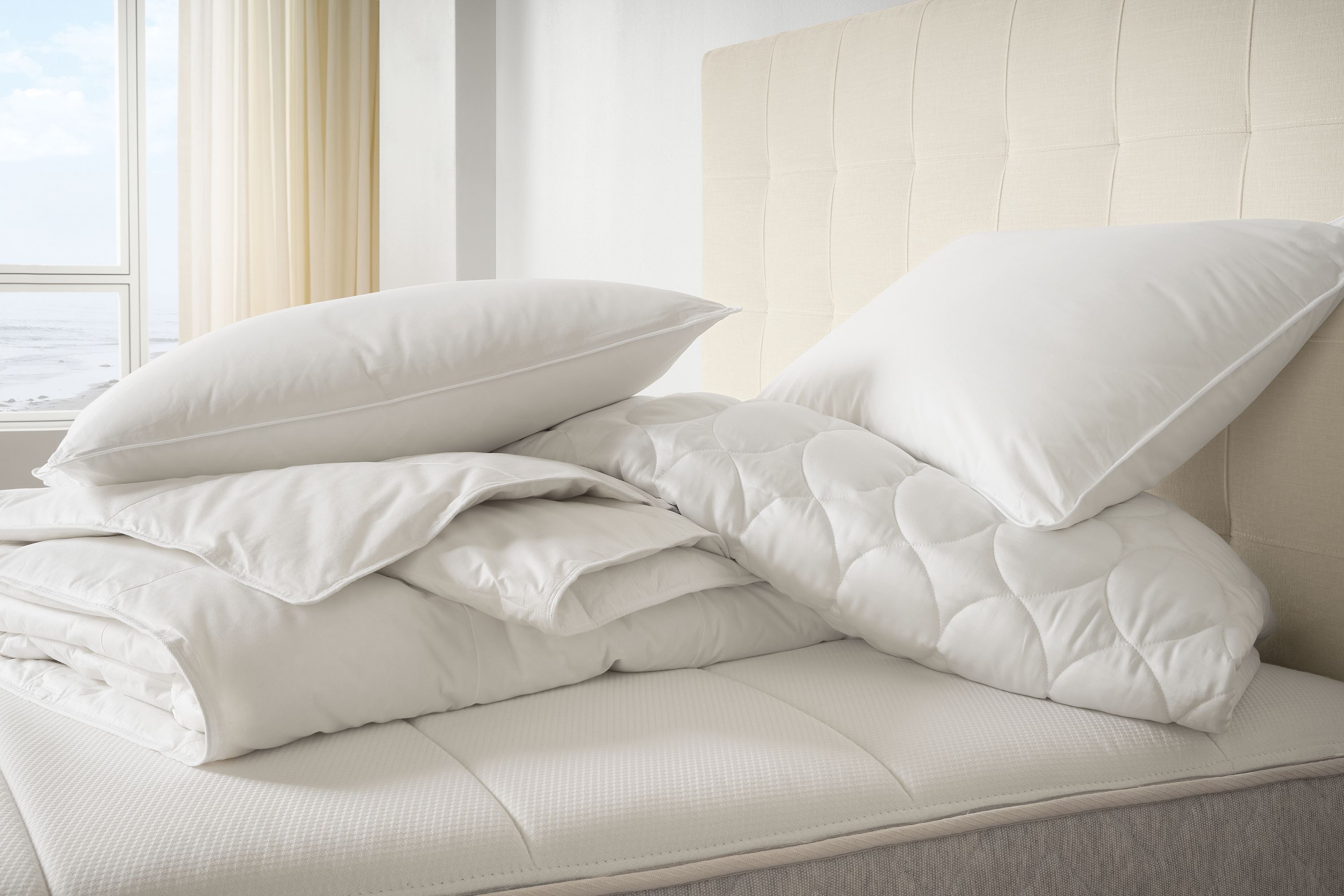 Detail of All season down duvet and tencel queen mattress pad in white on a Avery bed in Mori Ivory.