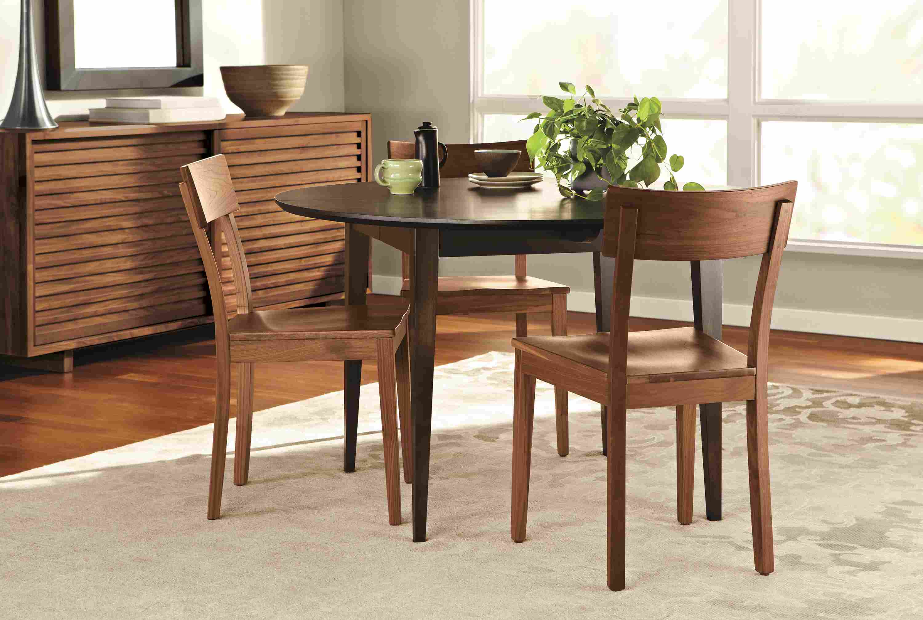 Dining room with Doyle side chair with wood seat in walnut.