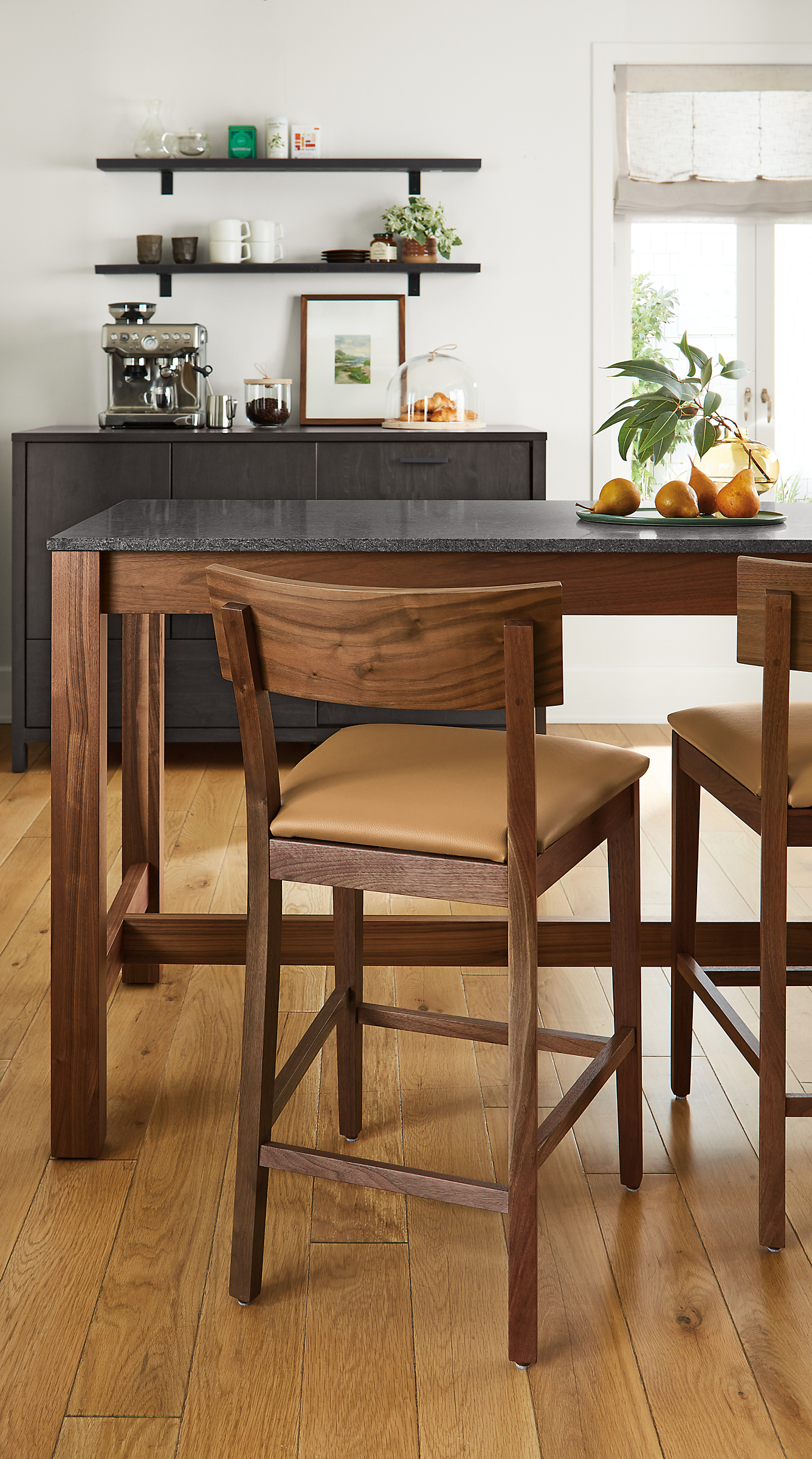 dining area with doyle counter stools in walnut and leather, linden counter table and emerson fridge cabinet.