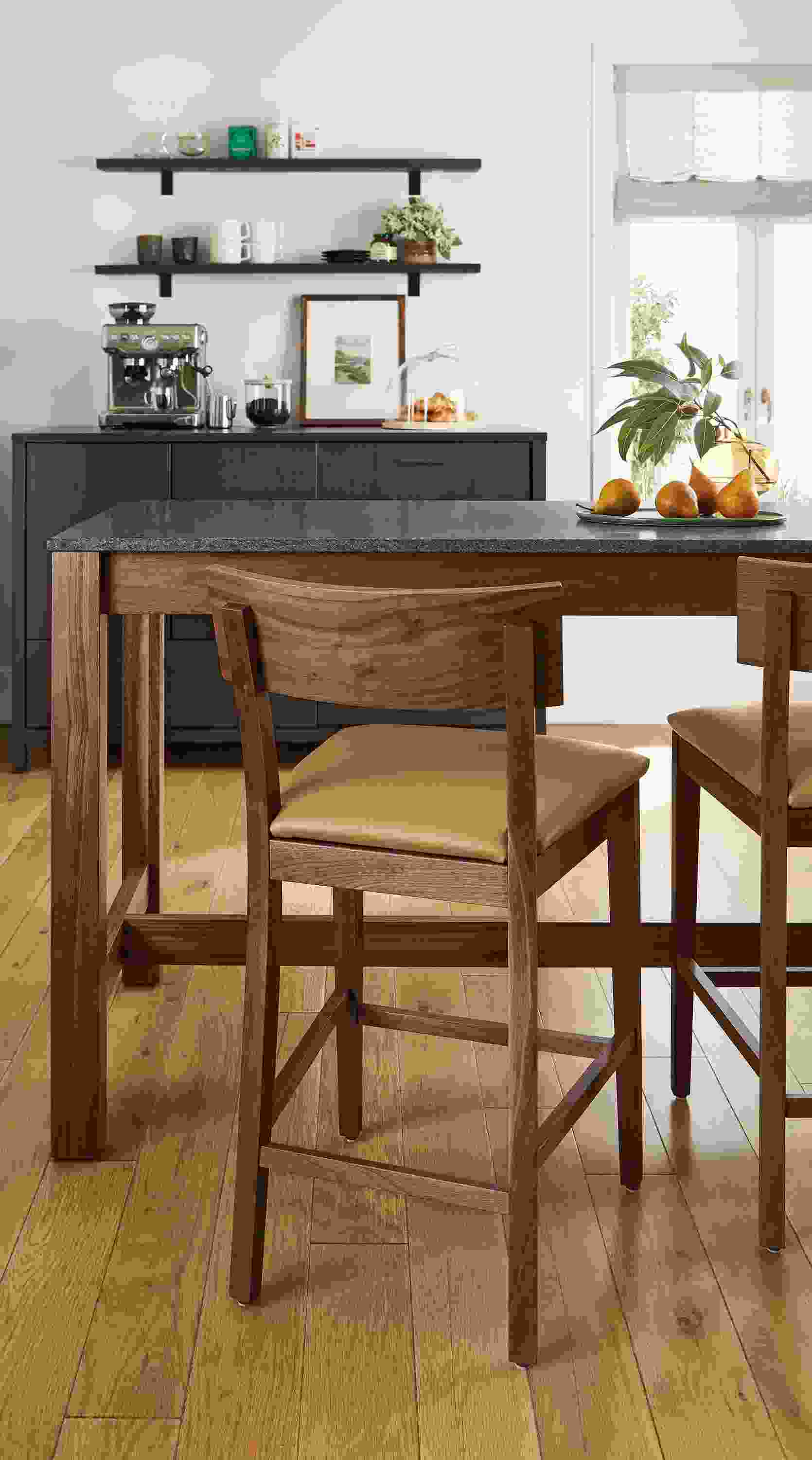 dining area with doyle counter stools in walnut and leather, linden counter table and emerson fridge cabinet.