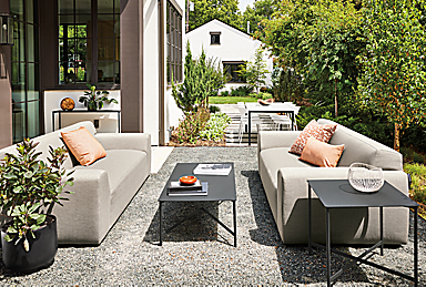 outdoor space with two drift sofas in pelham cement, and circuit coffee table and side table.