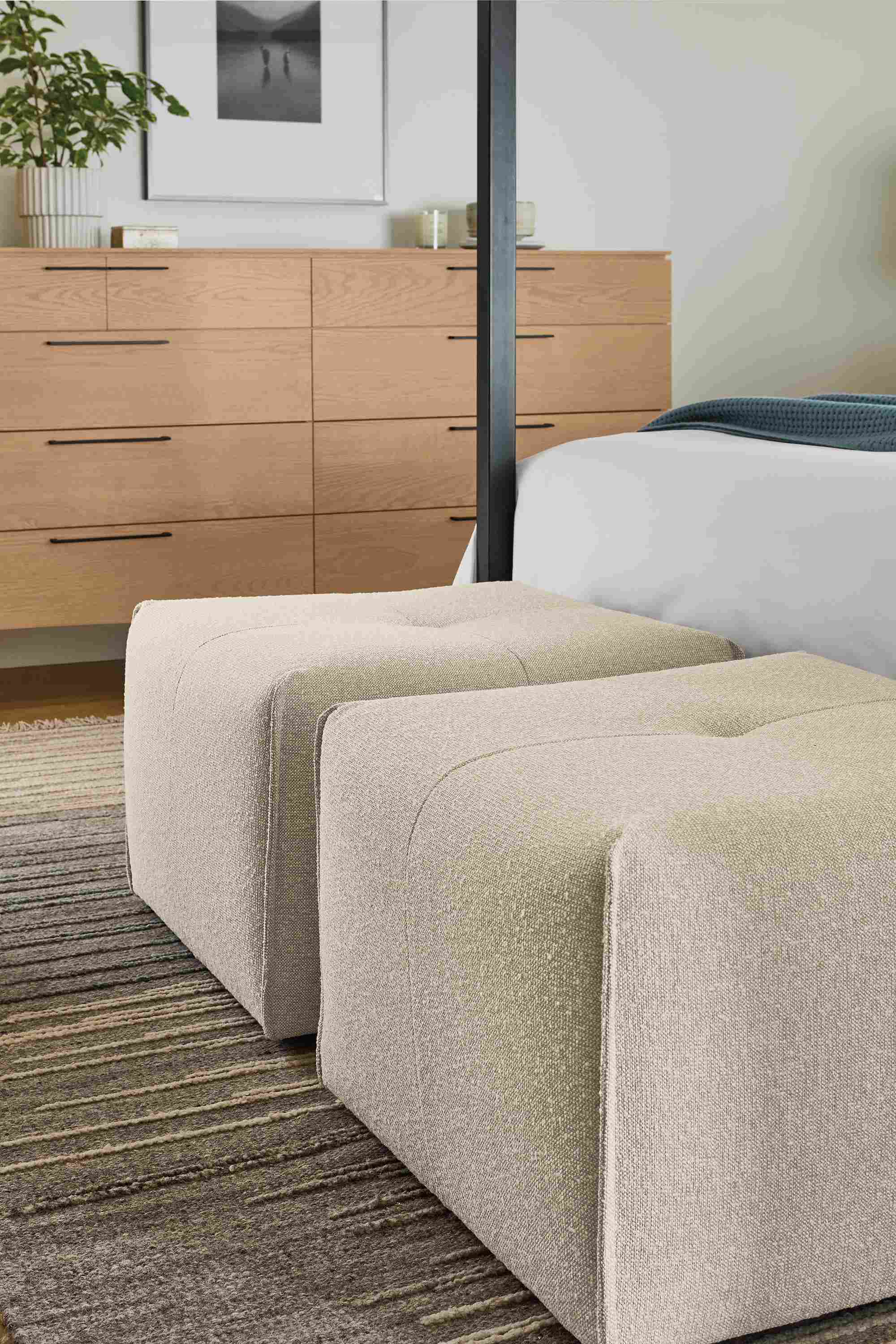 Bedroom with 2 dupree ottomans in conley natural, tangier rug in natural and Kenwood 10-drawer dresser in rye on red oak.