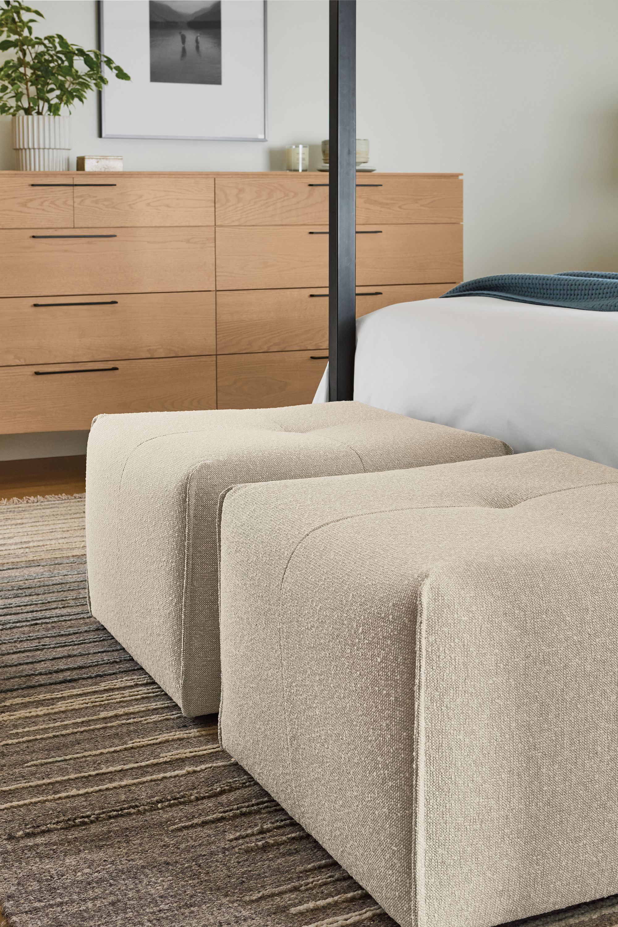Bedroom with 2 dupree ottomans in conley natural, tangier rug in natural and Kenwood 10-drawer dresser in rye on red oak.