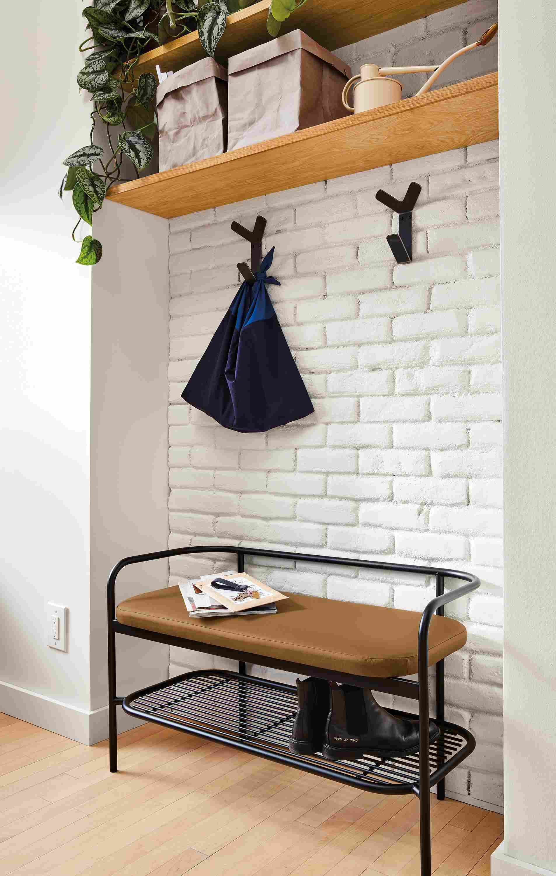 Detail of Ebers bench in graphite and Pesaro Camel leather in entryway.