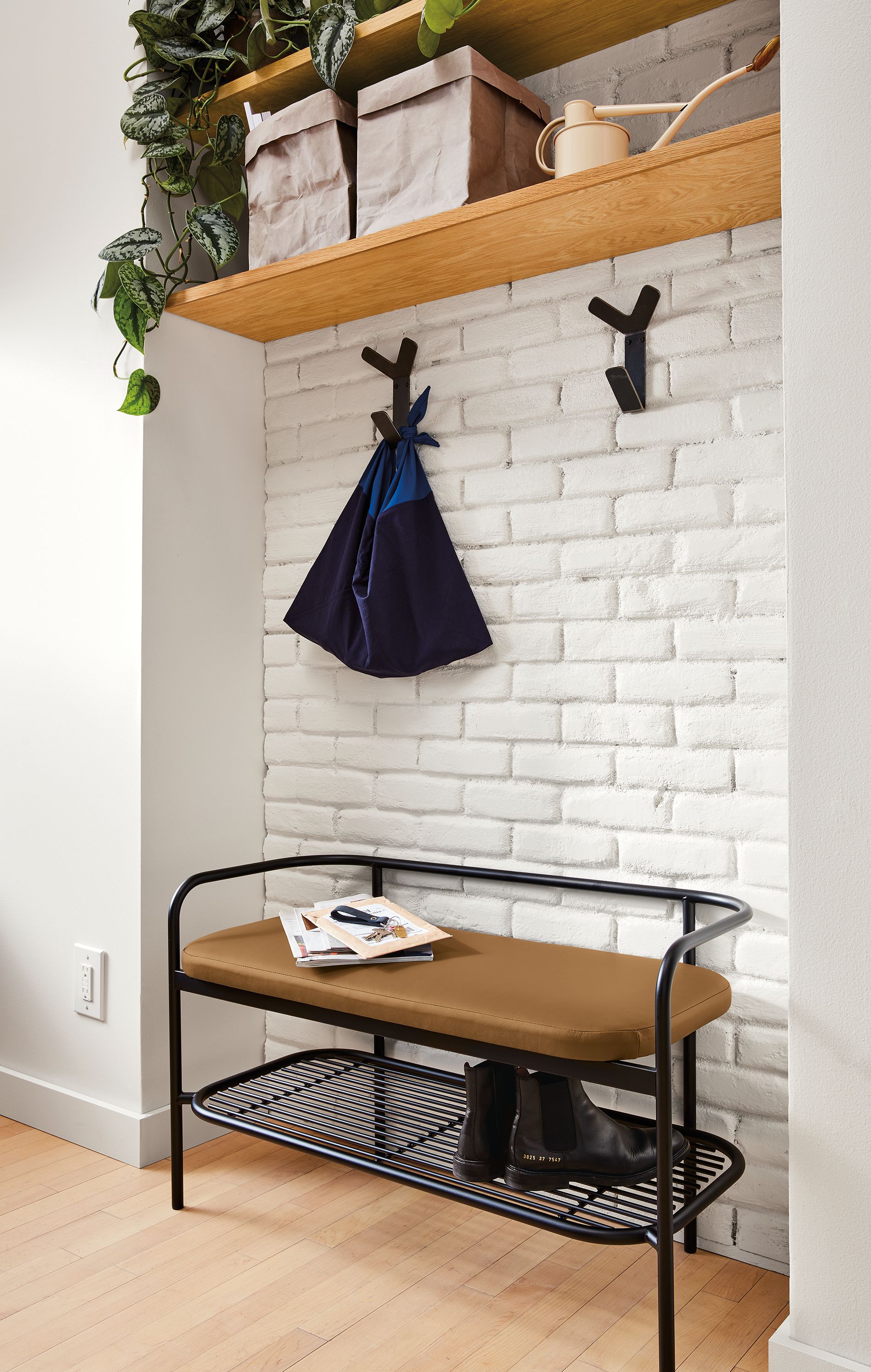 Detail of Ebers bench in graphite and Pesaro Camel leather in entryway.