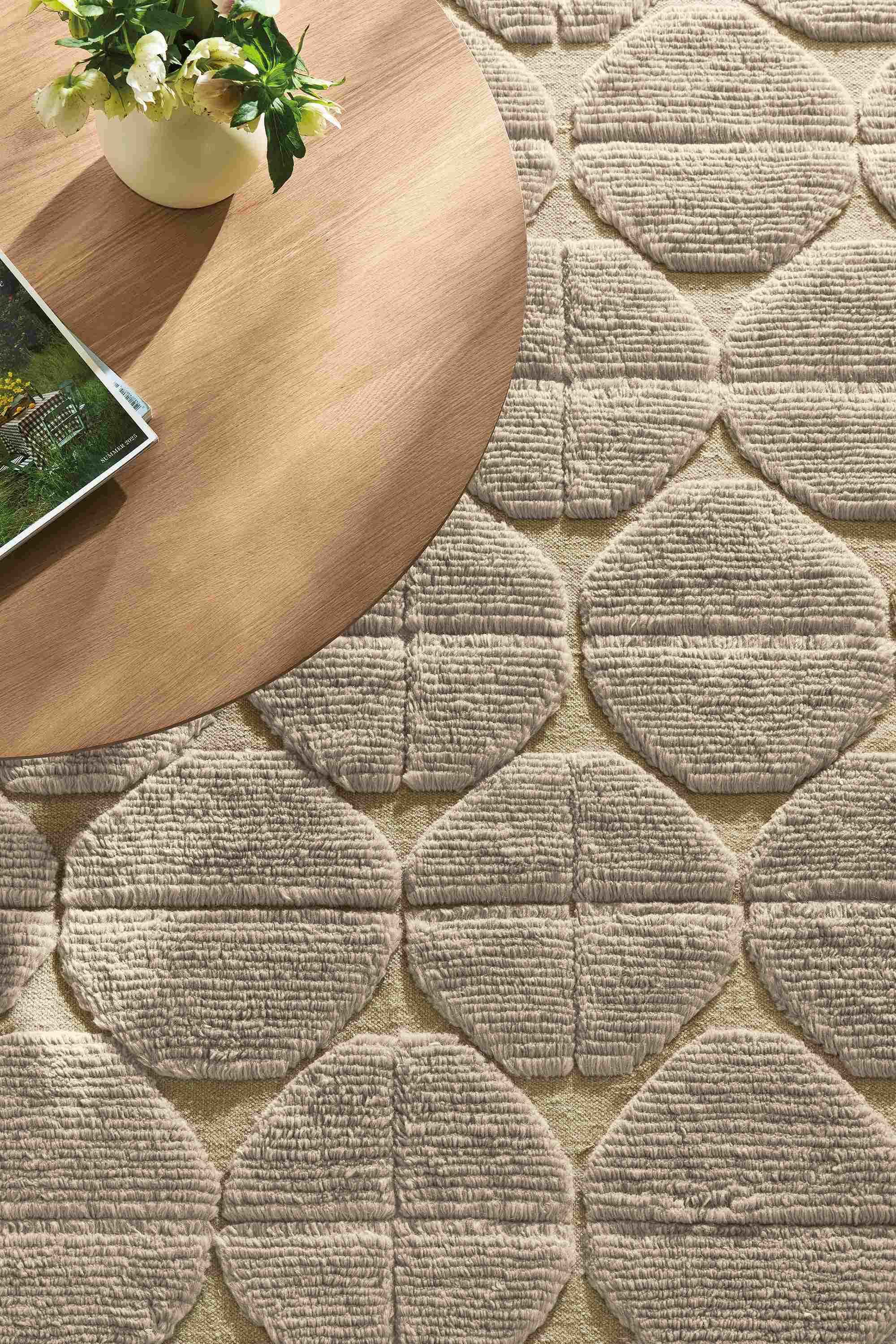 Overhead view of Edo 8 by 10 rug in Asphalt and decker 36-diameter round coffee table in rye on red oak.