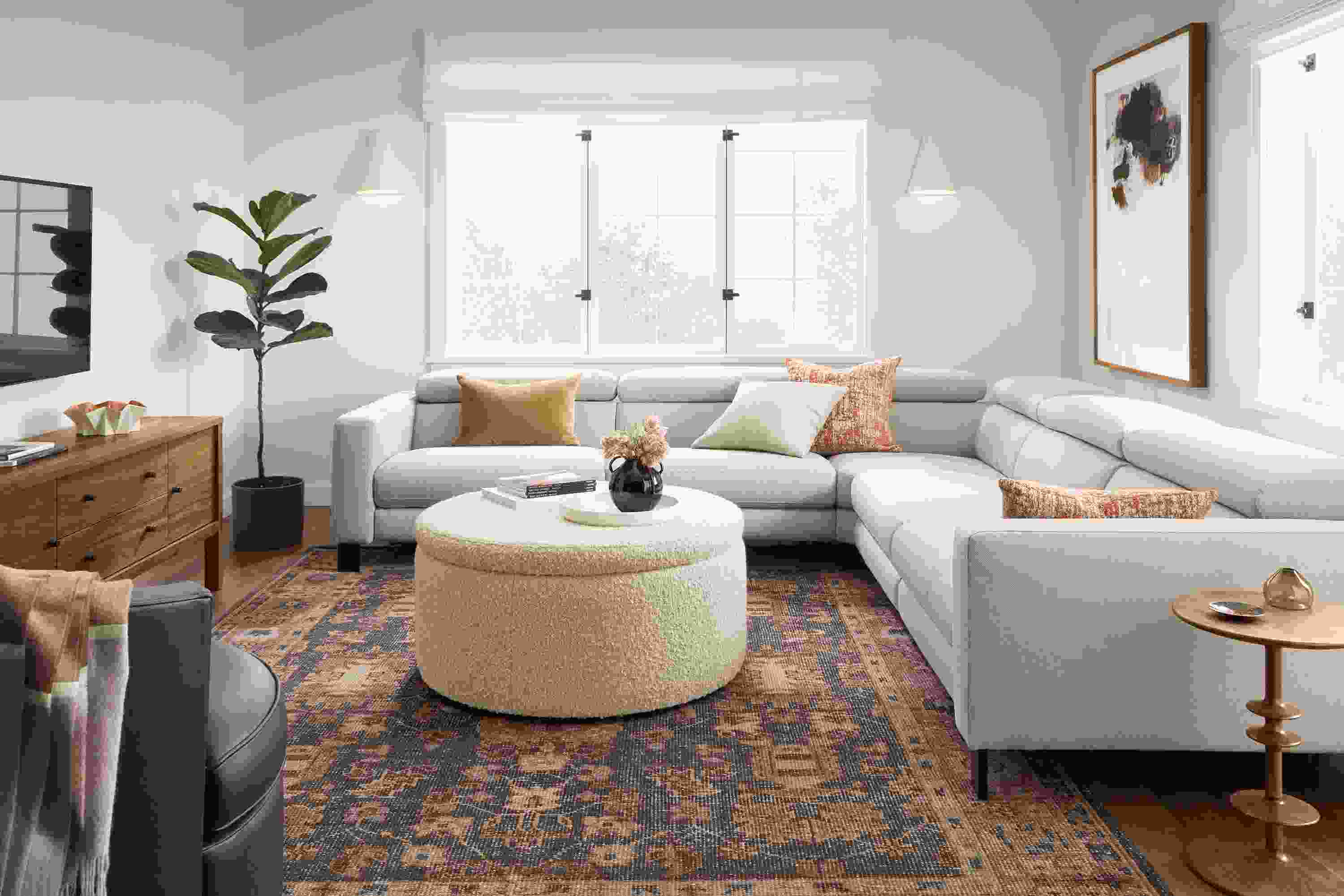 Living room with Elio sectional in sussex cement, Lind storage ottoman in dornick ivory, parks end table and Tillia rug.