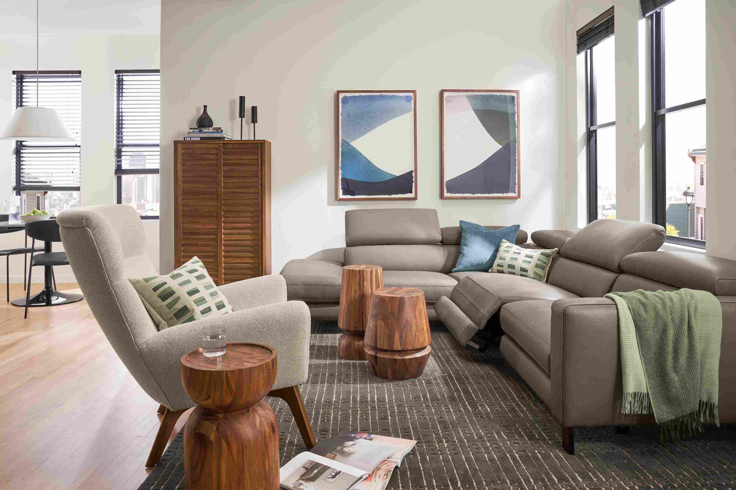 Living room with Elio leather sectional in dario smoke with two headrests and one footrest extended.