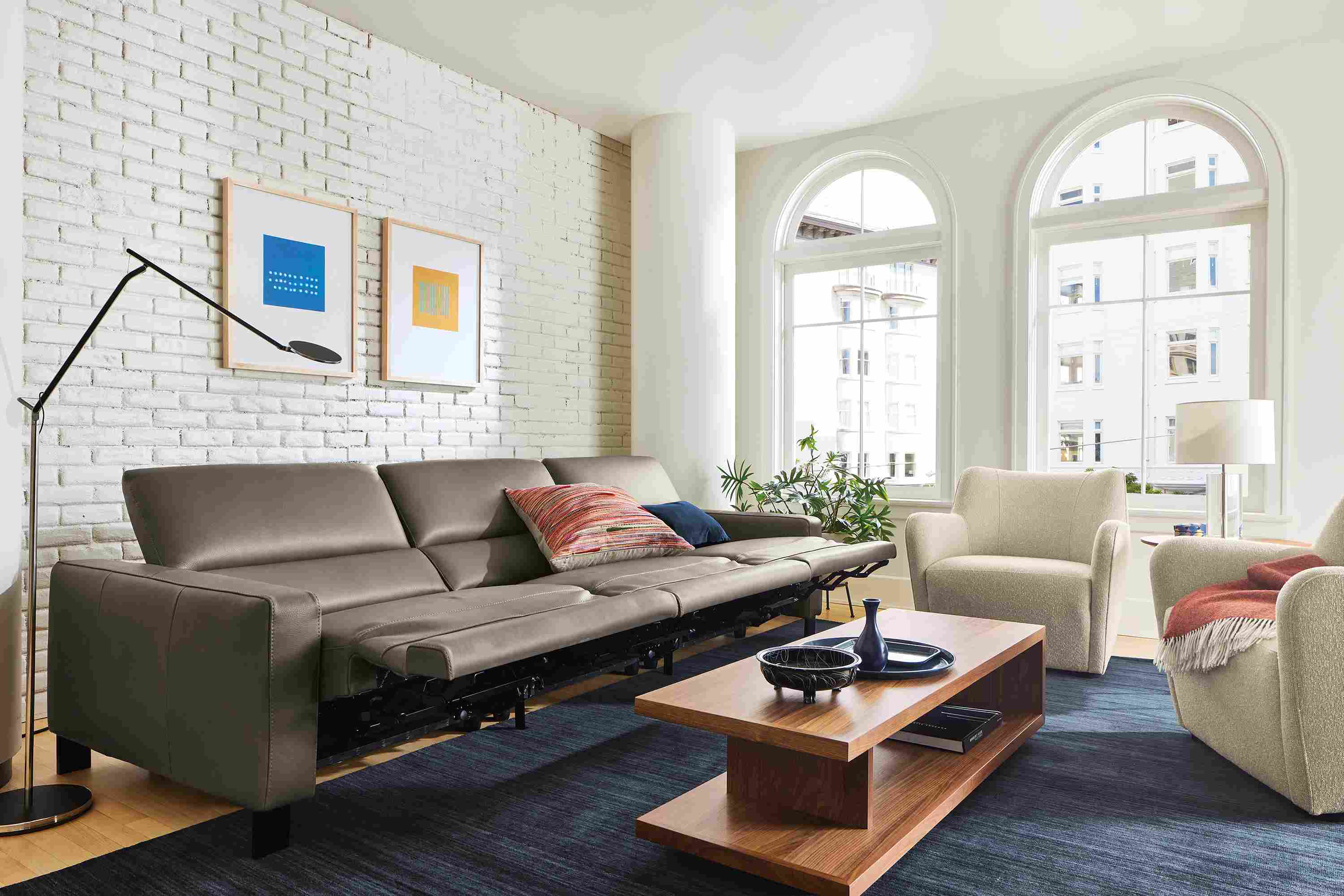 Living room with Elio sectional in dario smoke leather shown with all seats in reclining position.