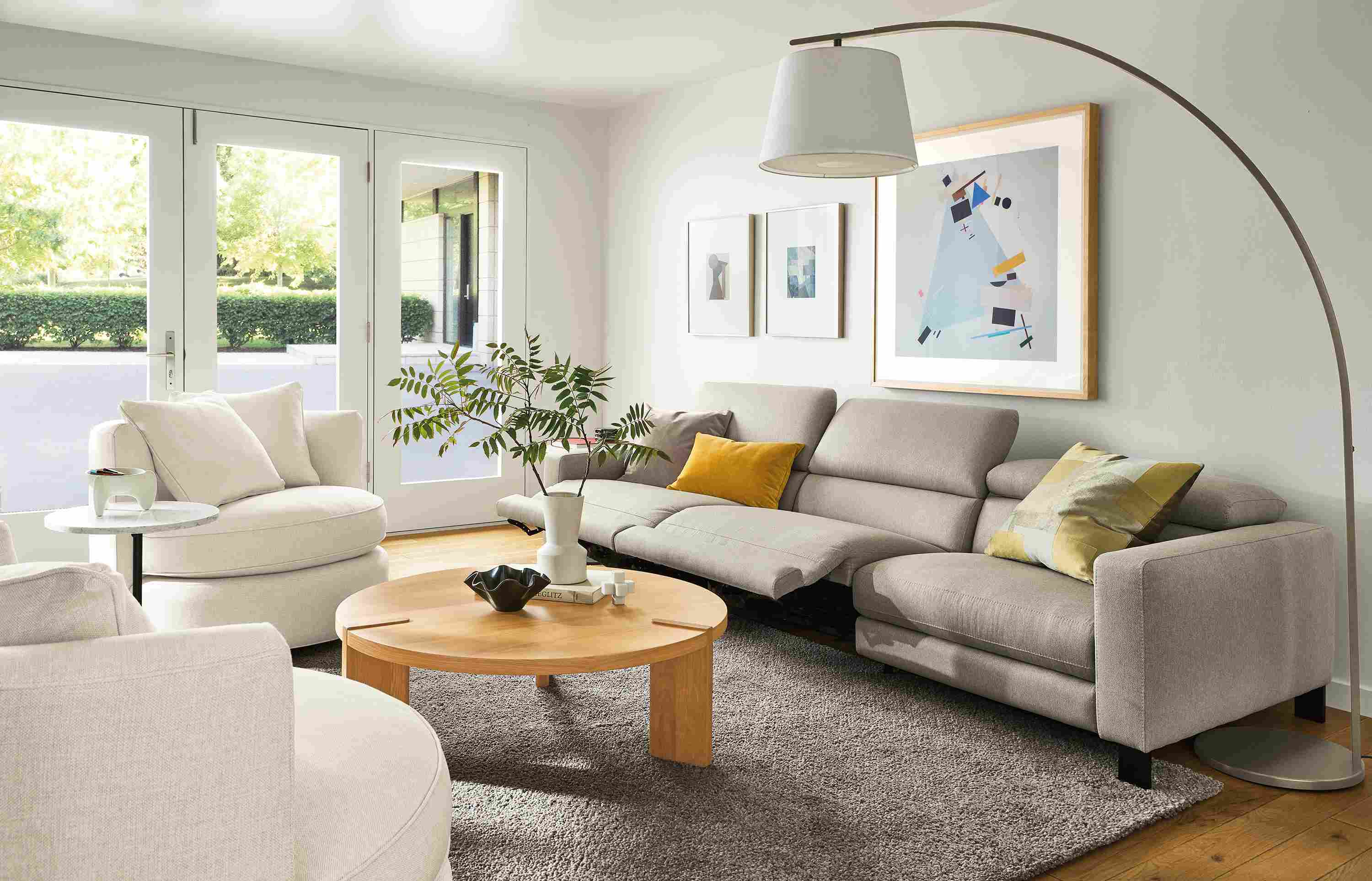 Living room with Elio sofa in Sussex cement with two seats in the reclining position and Hanover coffee table in white oak.