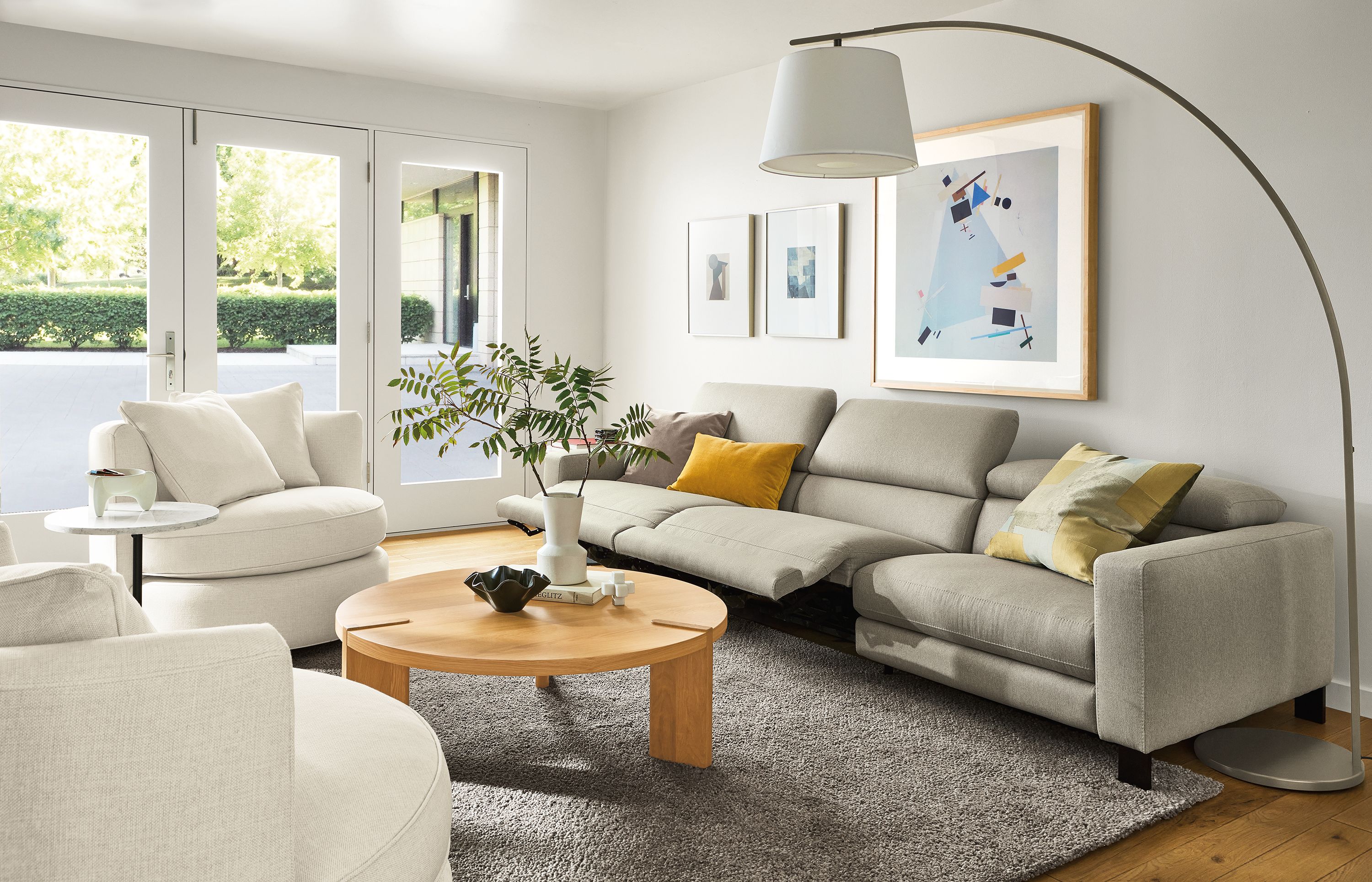 Living room with Elio sofa in Sussex cement with two seats in the reclining position and Hanover coffee table in white oak.