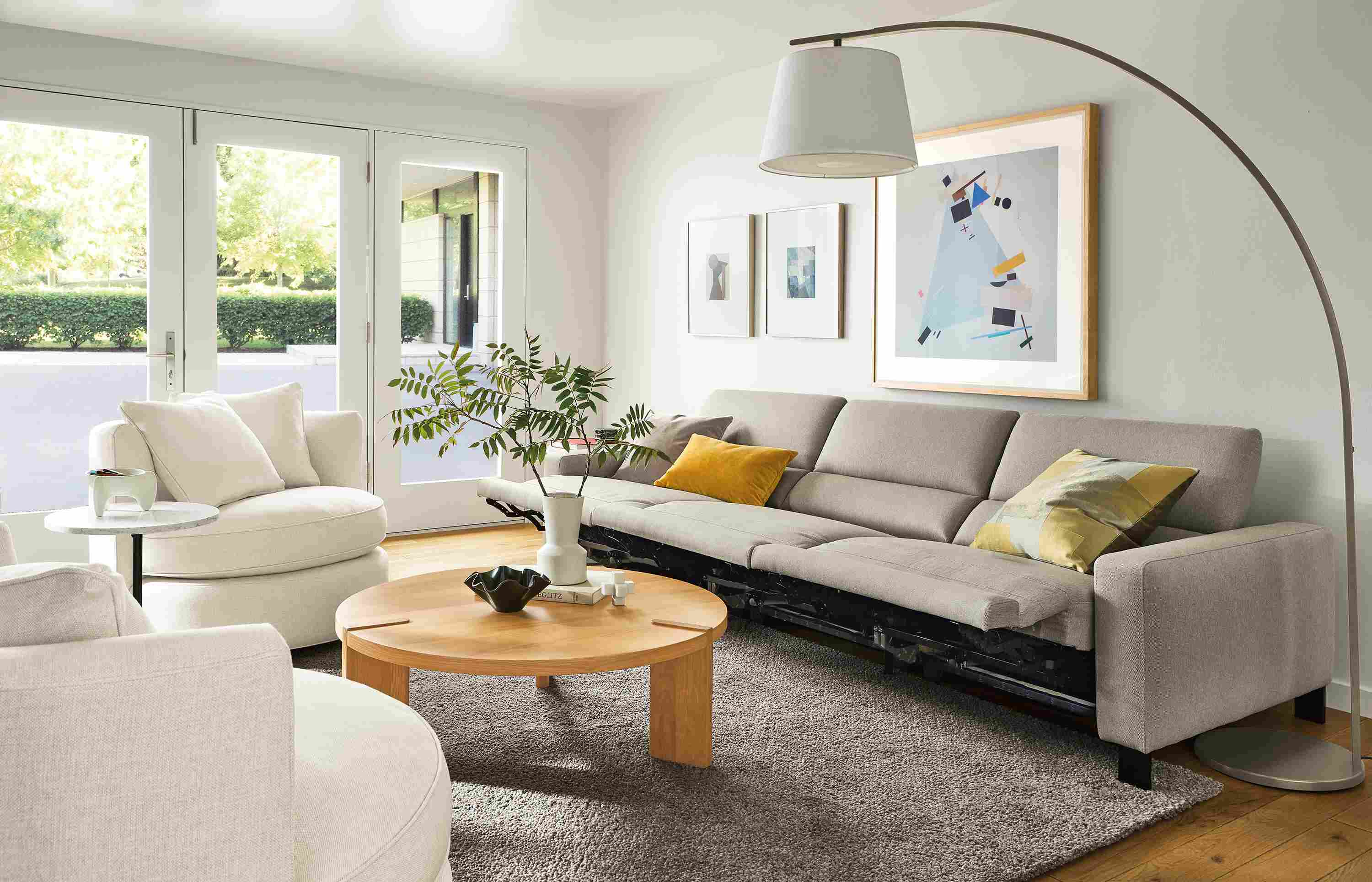 Living room with Elio sofa in Sussex Cement fabric with all three seats in the reclining position.