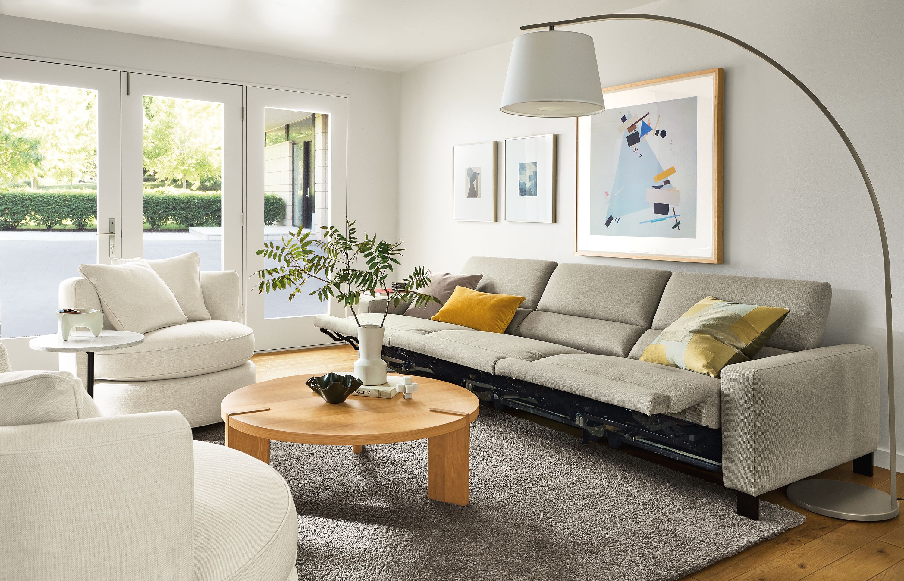 Living room with Elio sofa in Sussex Cement fabric with all three seats in the reclining position.