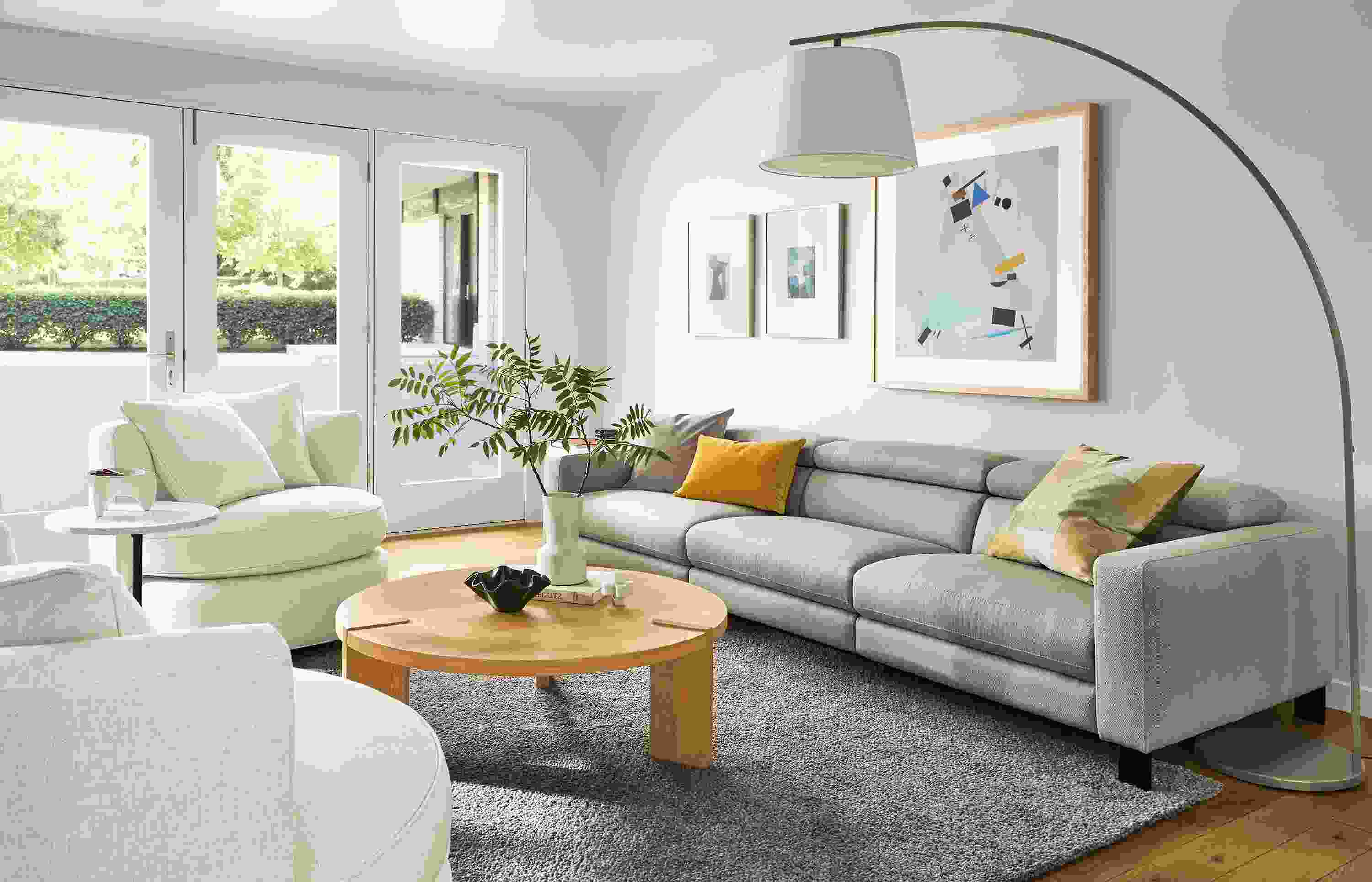 Living room with Elio sofa in Sussex cement with Eos swivel chairs in sumner ivory and Hanover coffee table in white oak.