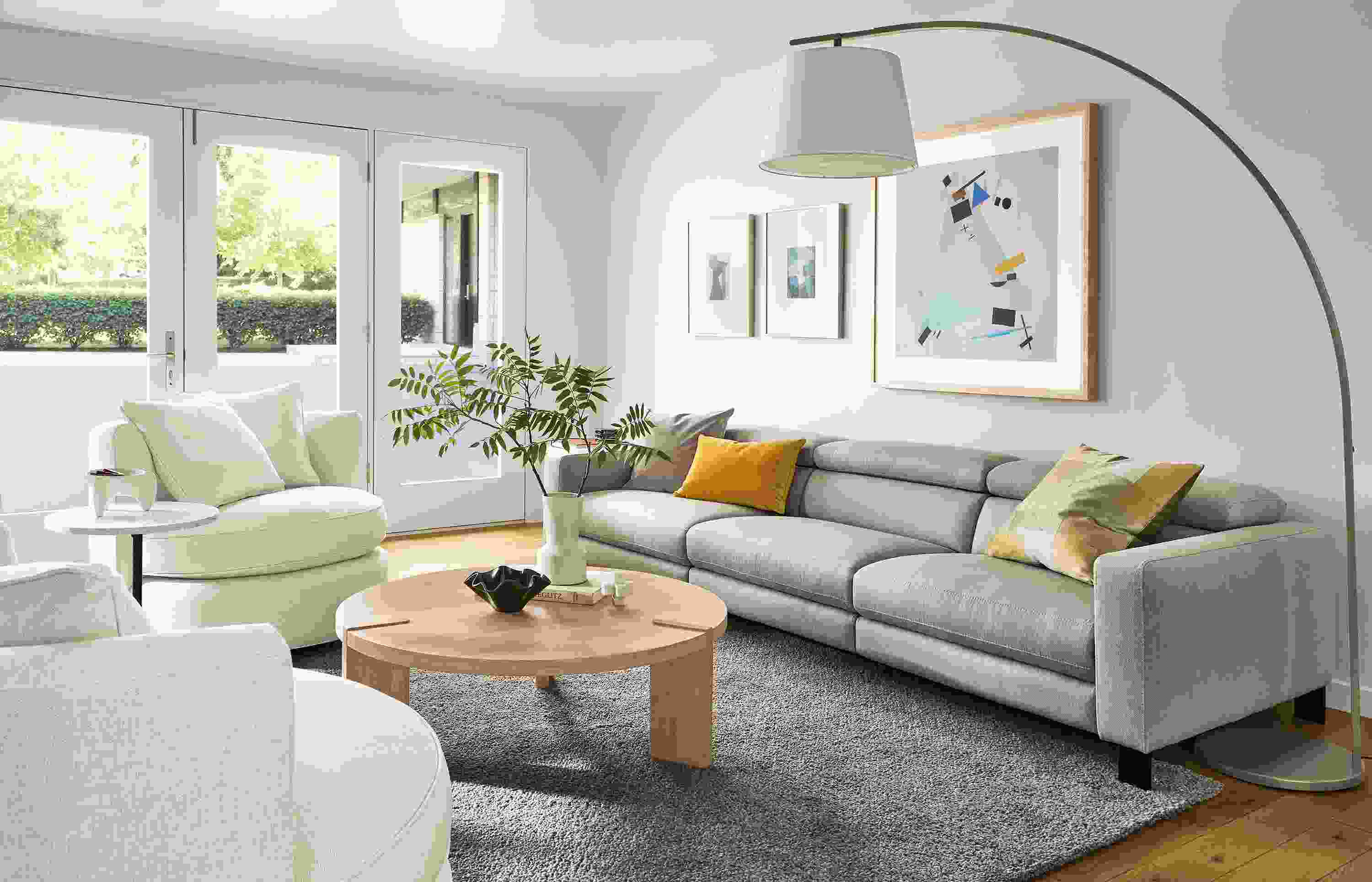 Living room with elio sofa in sussex cement, eos swivel chairs in sumner ivory and Hanover coffee table in rye on red oak.