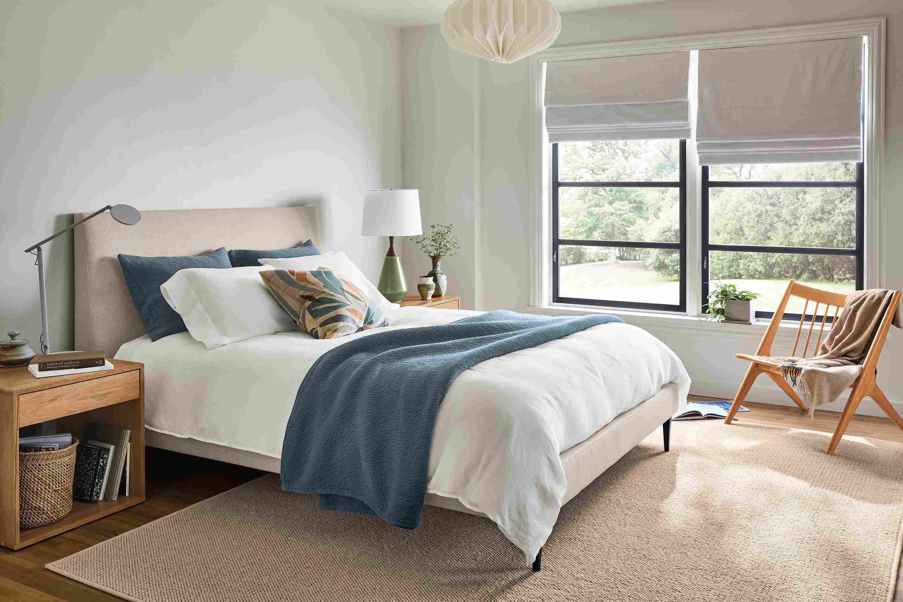 Bedroom with Ella queen bed in sumner linen, Graft end table in reclaimed white oak and Oskar armless lounge chair in cherry.