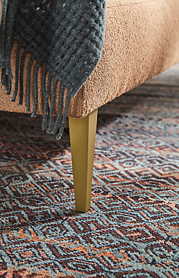 Detail of Ella queen bed's brushed gold leg.