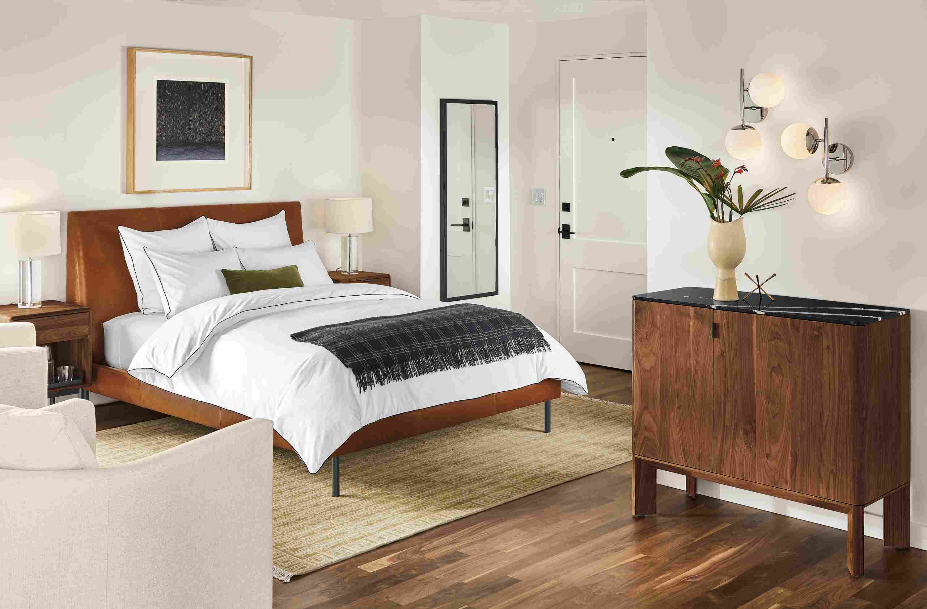Detail of Ella queen bed in Vento Cognac leather in bedroom with Pren bar cabinet.