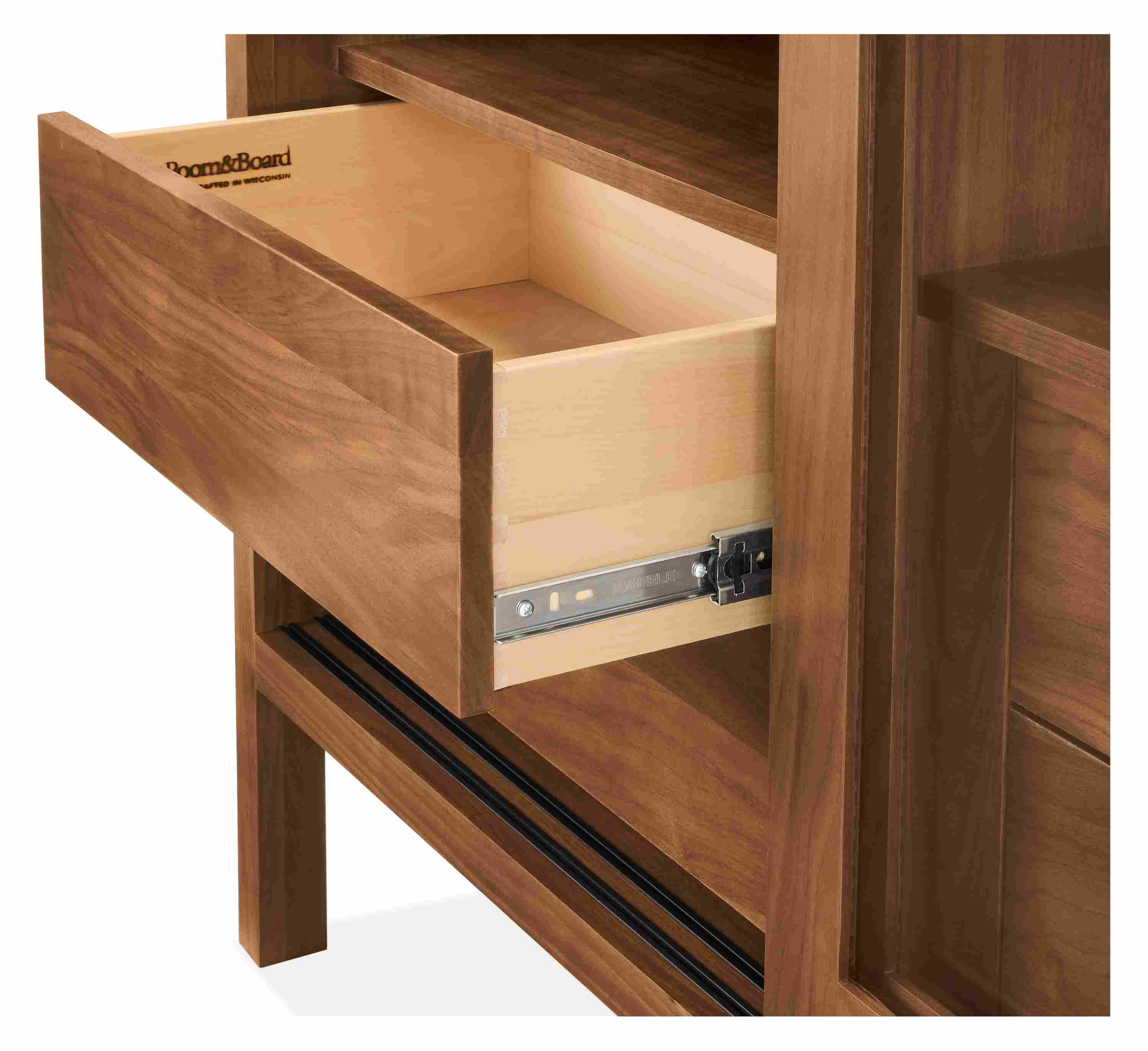 Detail of an Emerson 2-glass door, 4-drawer storage cabinet in walnut shown with one drawer open.