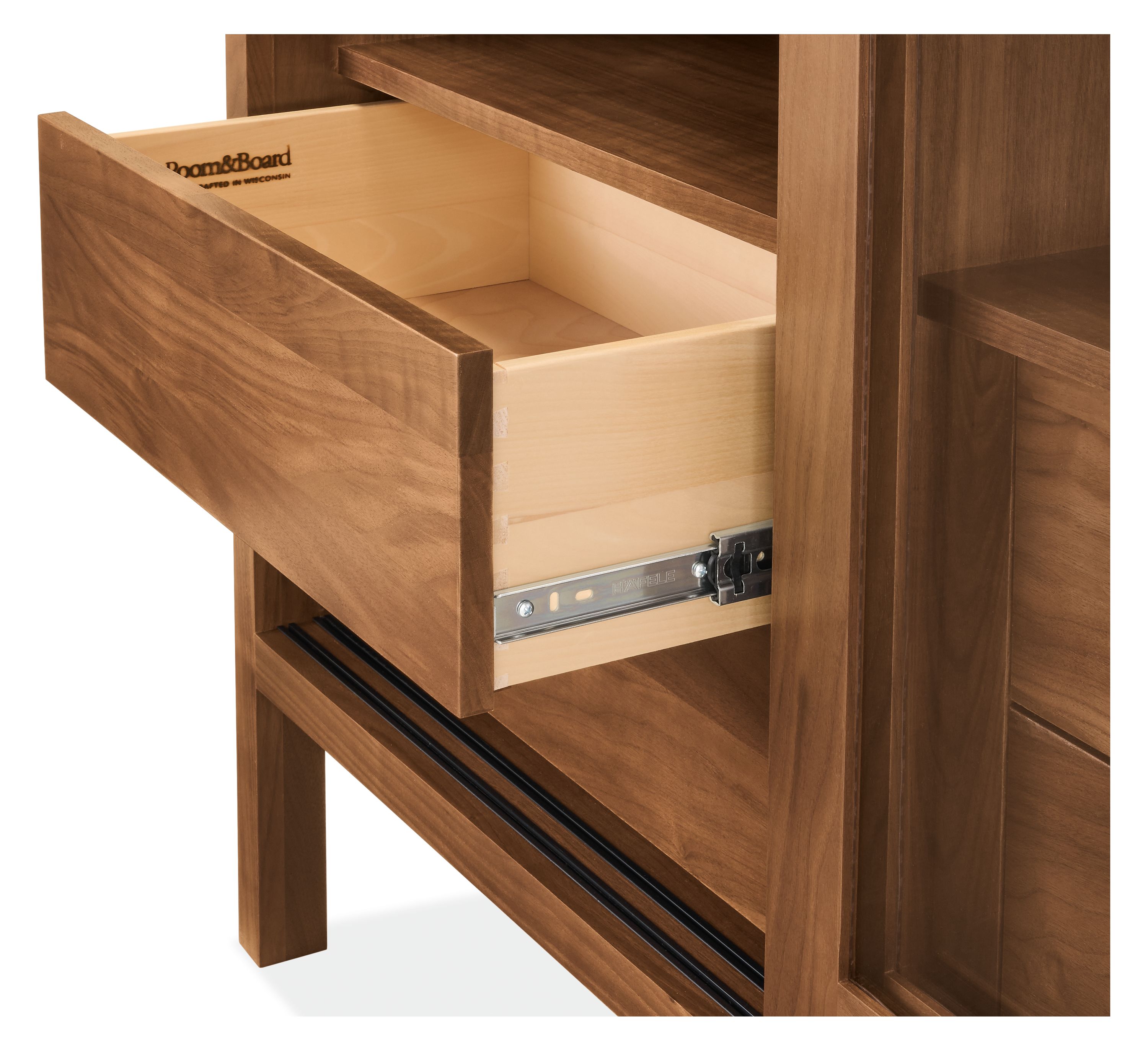 Detail of an Emerson 2-glass door, 4-drawer storage cabinet in walnut shown with one drawer open.