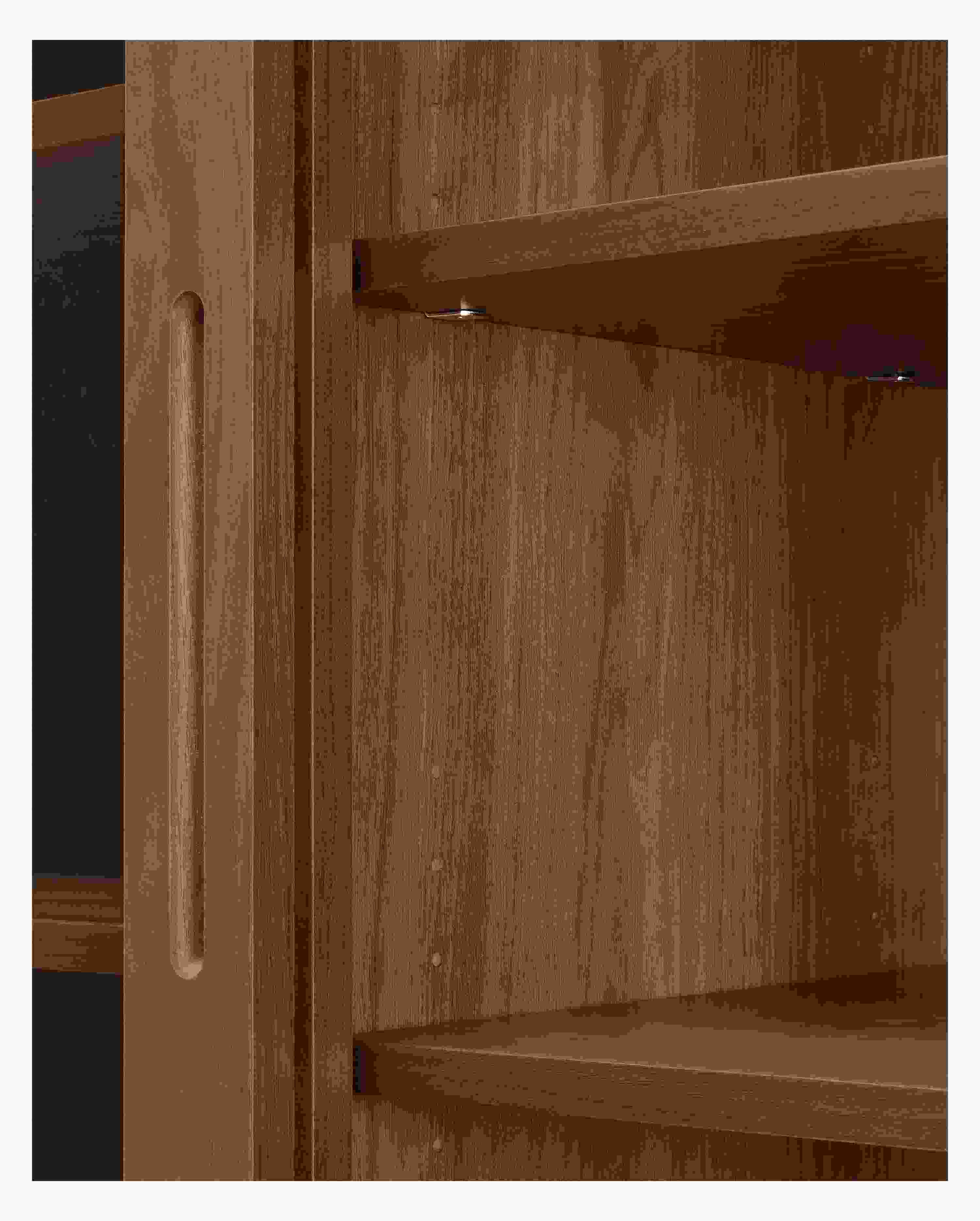 Emerson storage cabinet in walnut showing underside of shelves and shelf pins.