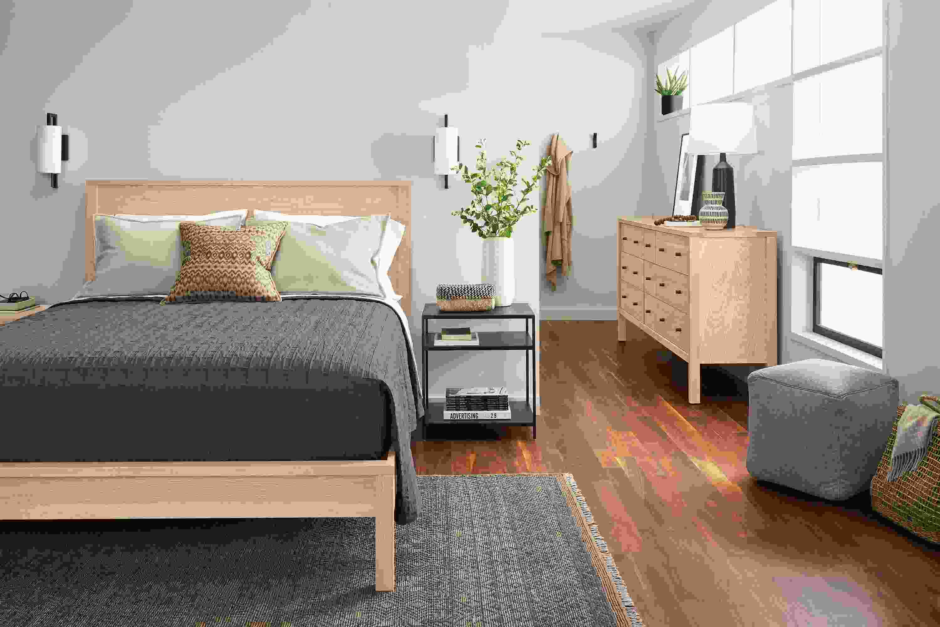 Bedroom with Emerson queen bed, nightstand and dresser in salt on red oak and slim end table in natural steel.