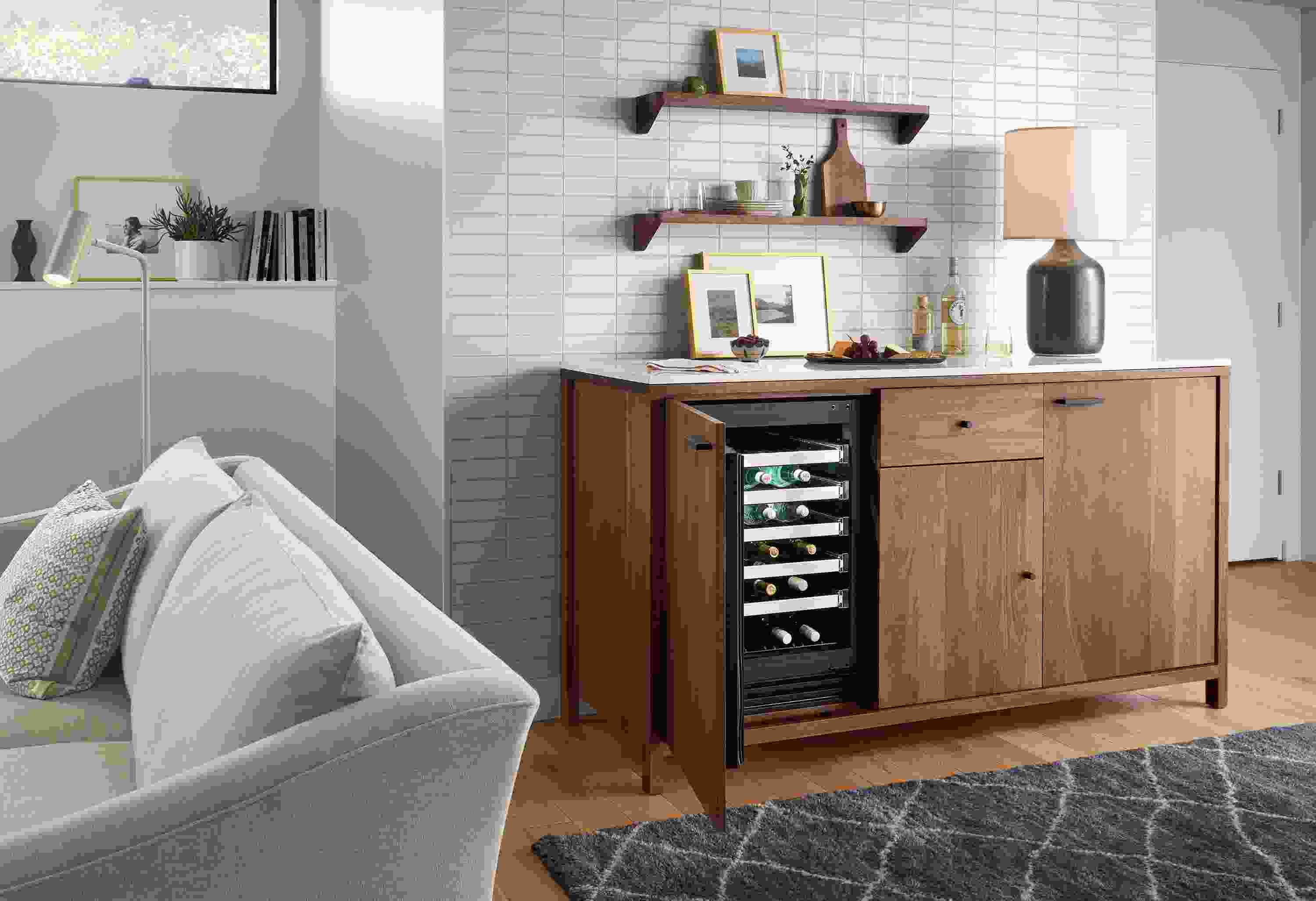 Living room with Emerson 72-wide double fridge cabinet in walnut, showing open wine fridge, and Kalindi 6 by 9 rug in Smoke.