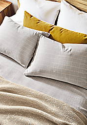 detail of emma coverlet and sham set in grey/beige on bed.