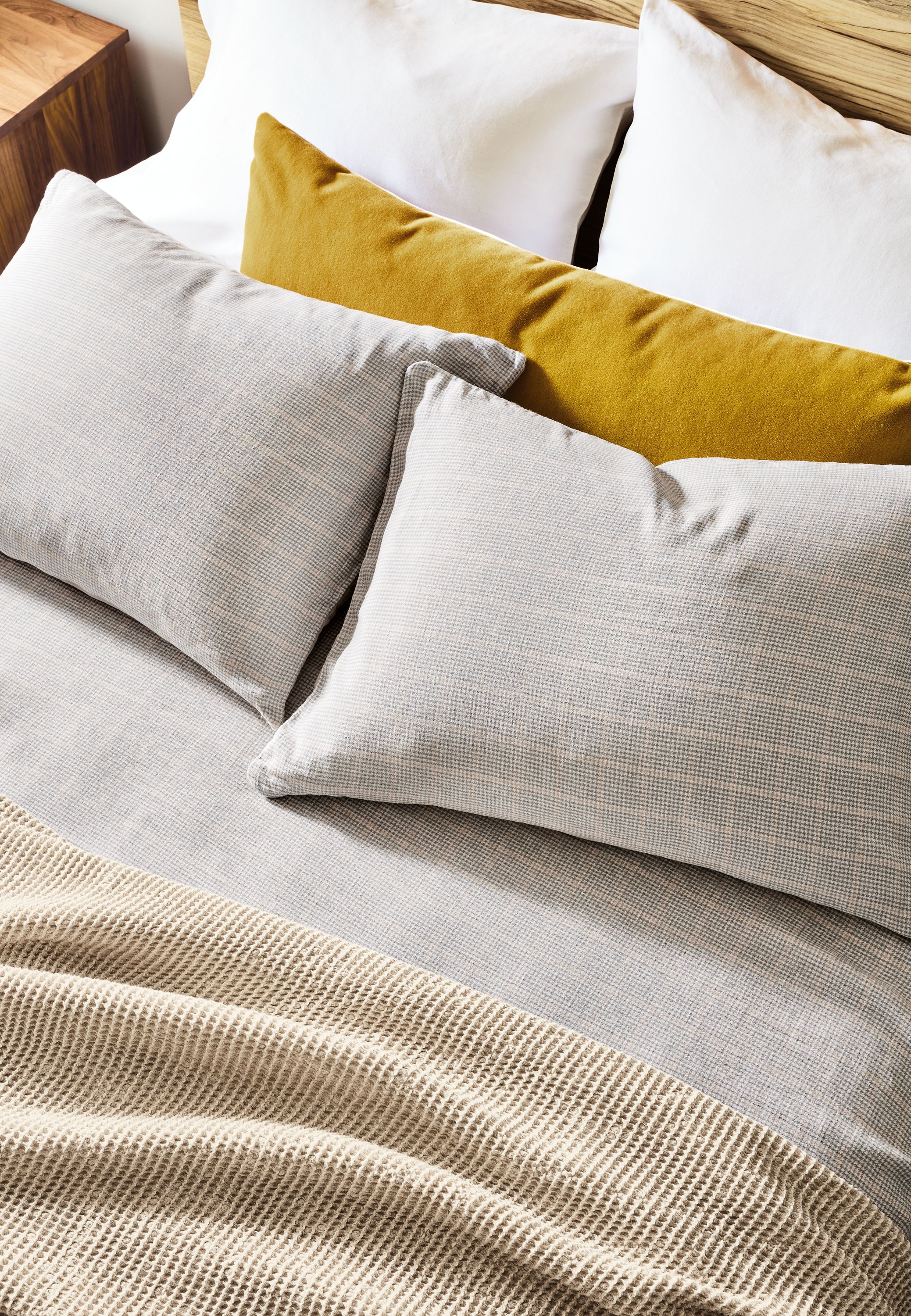 detail of emma coverlet and sham set in grey/beige on bed.