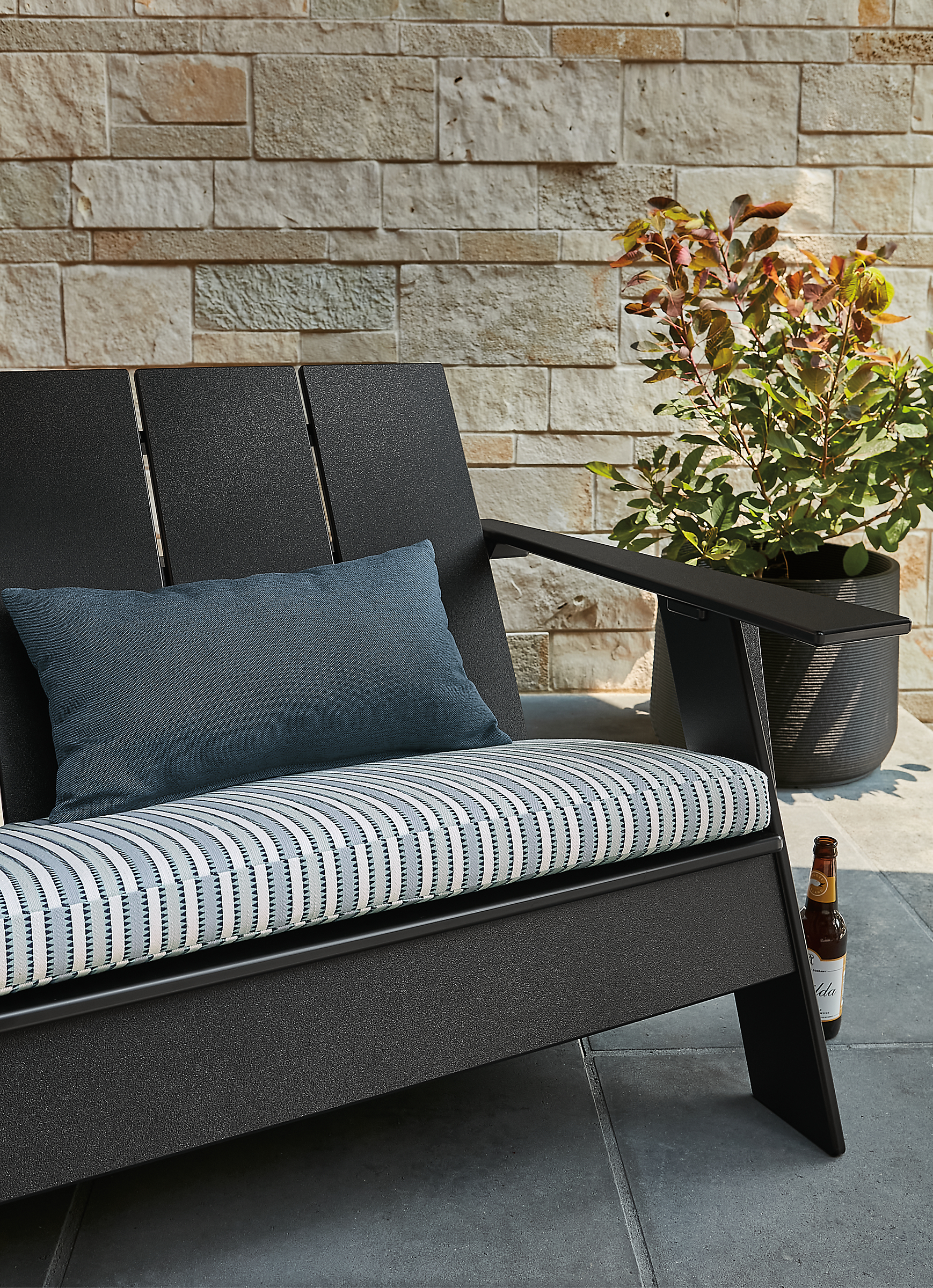 Outdoor space with emmet sofa with cushion, and ajax planter.