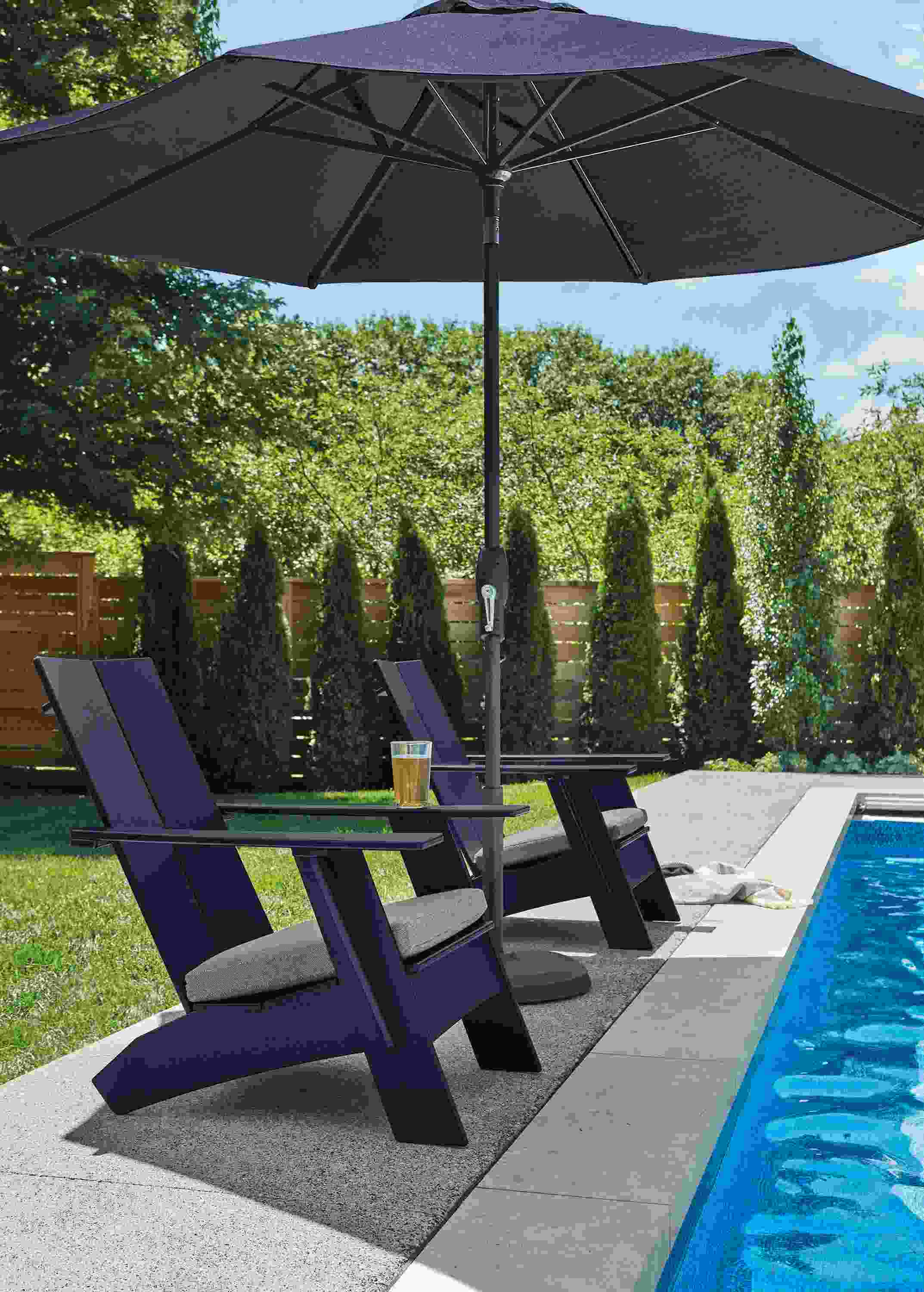 Pool area with 2 Emmet lounge chairs in Navy with Pelham grey fabric and Oahu 9-foot patio umbrella in tavros navy.