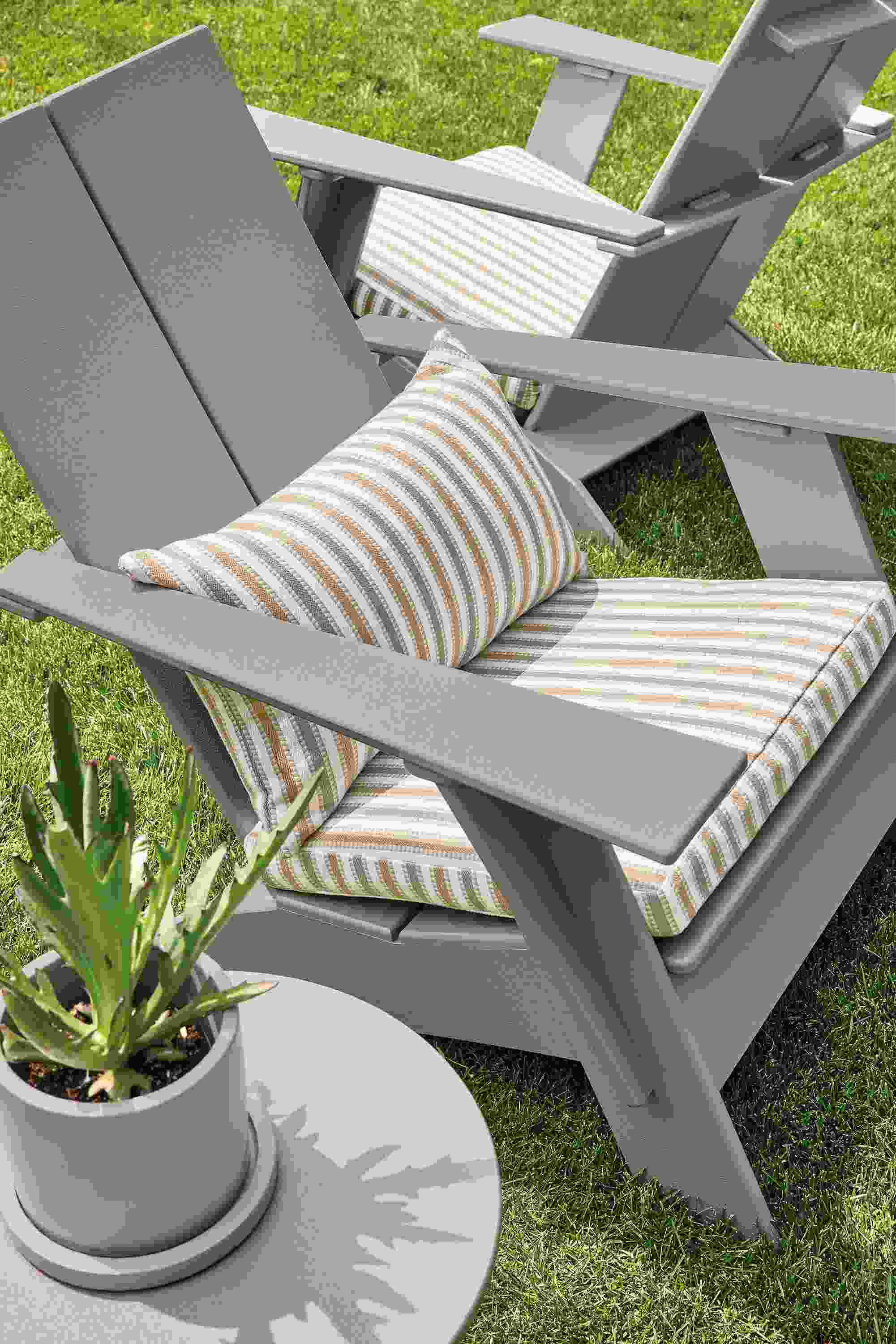 Outdoor space with emmet chair in putty with hex camel cushion and pillow, nova side table in putty and renga planter.
