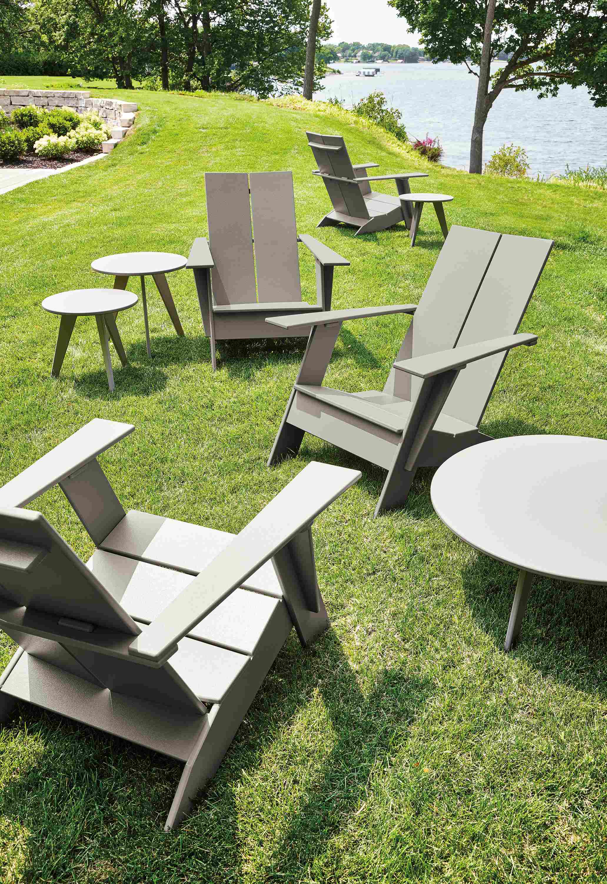 Grassy area near lake with Emmet lounge chairs and Nova tables in putty.