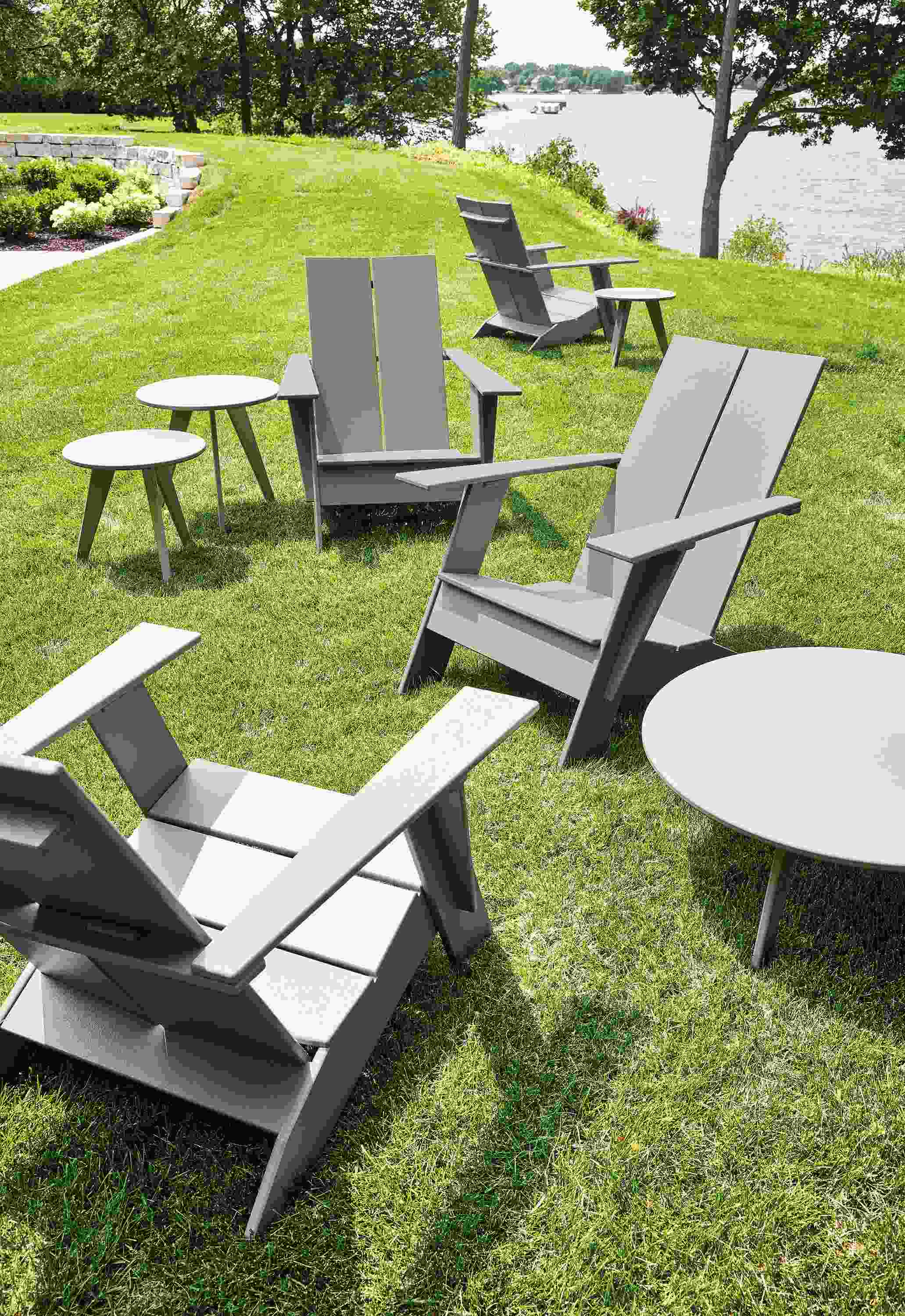 Grassy area near lake with Emmet lounge chairs and Nova tables in putty.