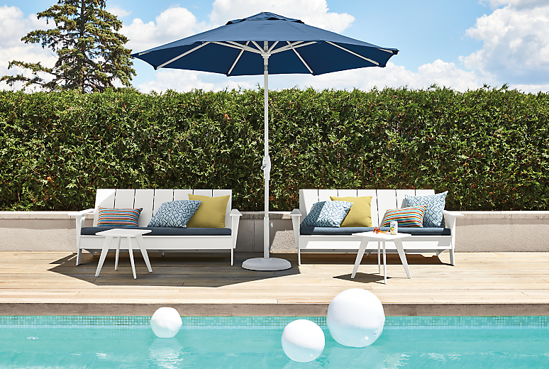 Two Emmet 70-inch sofas in white with Pelham ink cushions, two nova tables and Oahu umbrella in Oren blue.