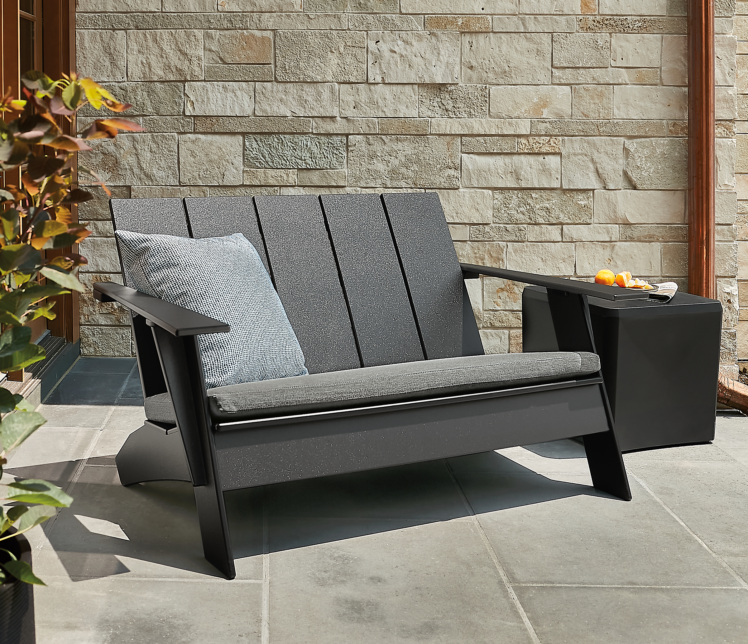 Outdoor space with emmet sofa with cushion, large bronson pillow, cusp square stool.