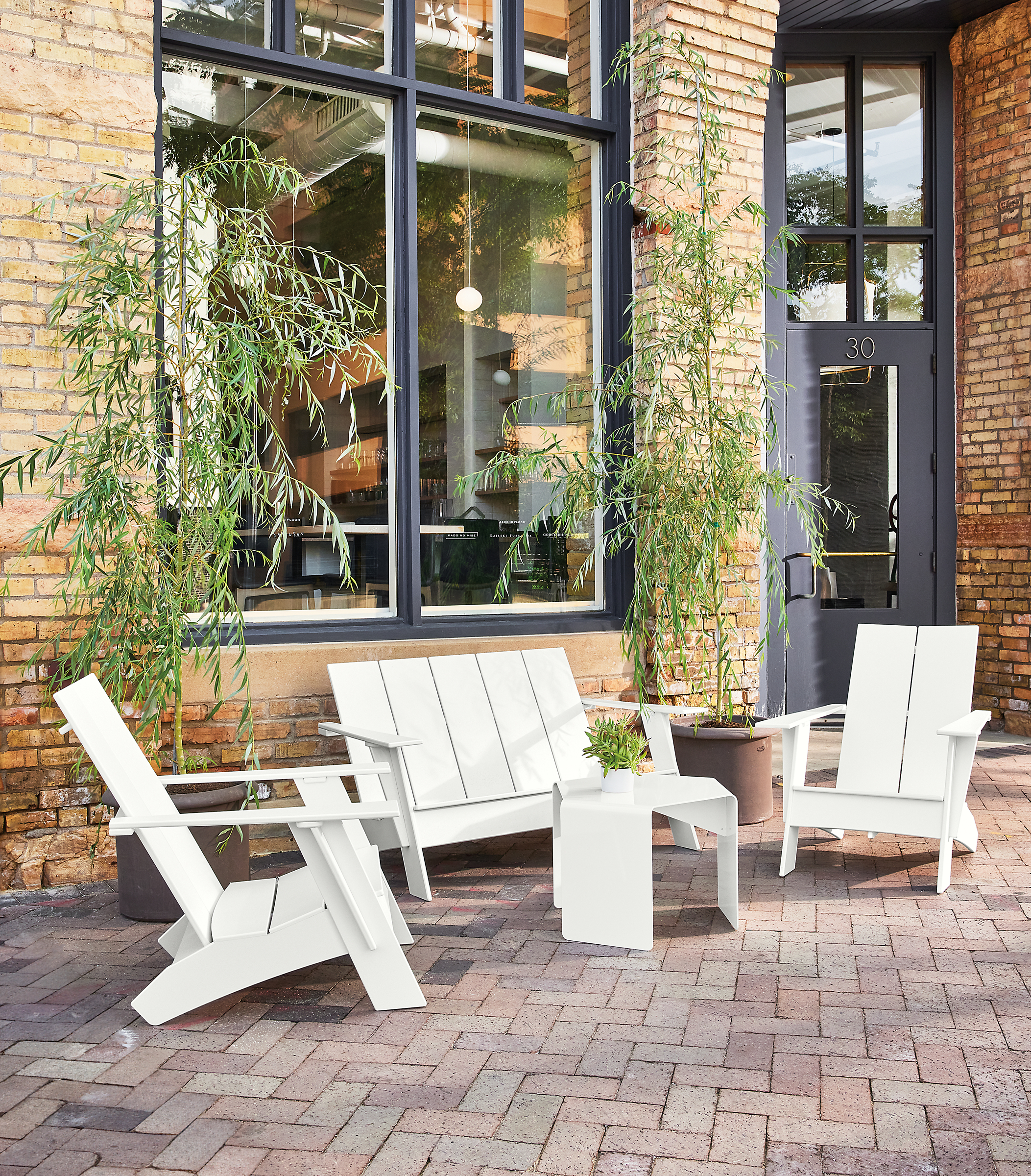 Outdoor space with emmet sofa, two emmet chairs, cell side table.