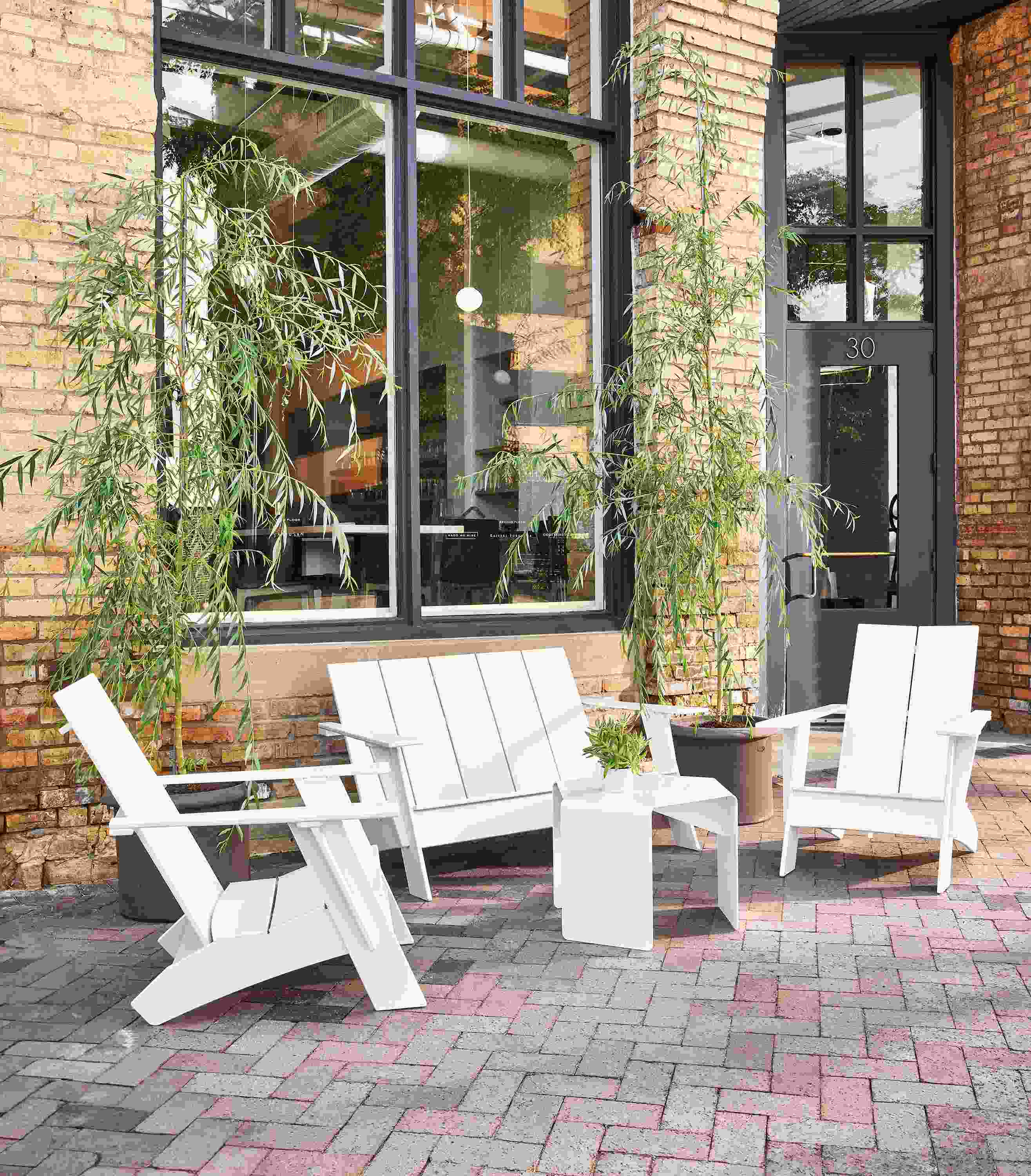 Brick patio with Emmet sofa, 2 Emmet chairs, cell side table all in white.