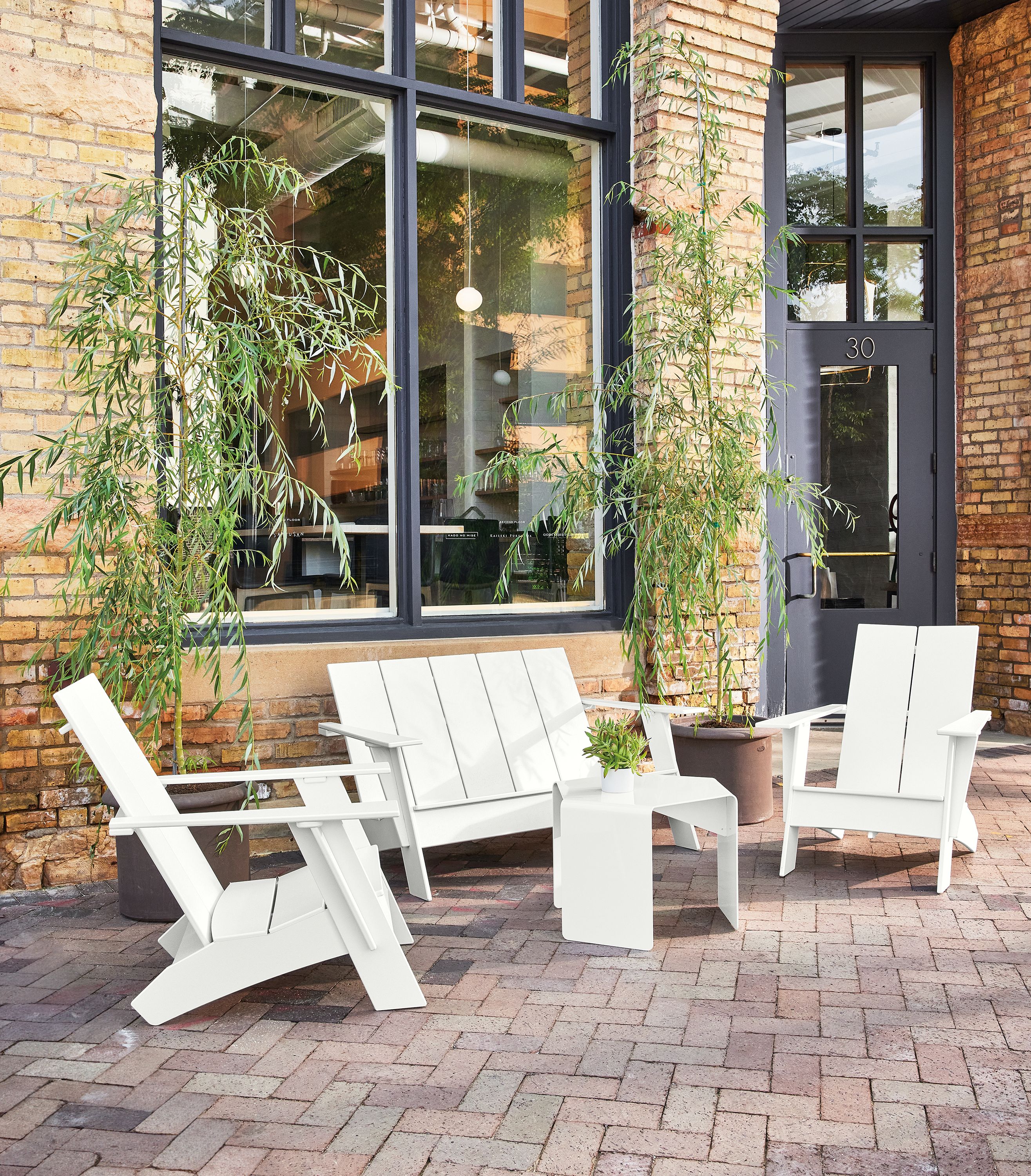 Brick patio with Emmet sofa, 2 Emmet chairs, cell side table all in white.