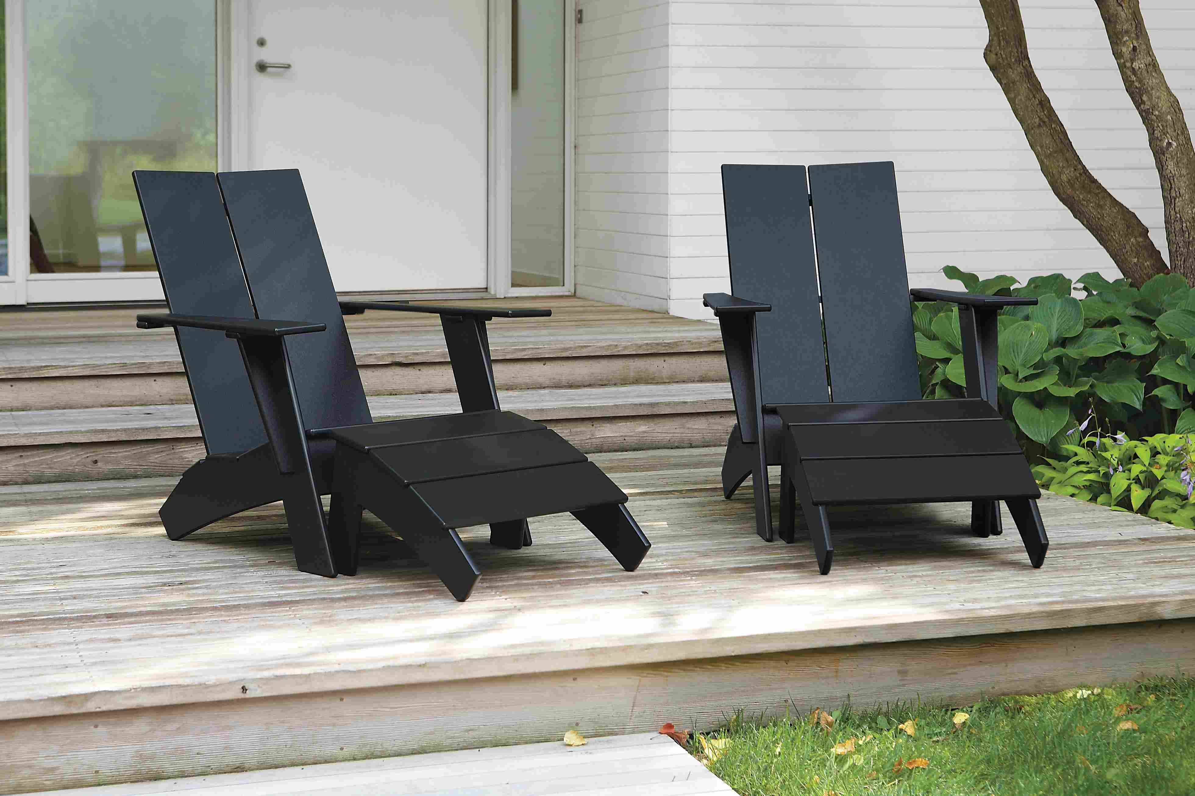 Wooden deck with 2 Emmet lounge chairs and ottomans in black.