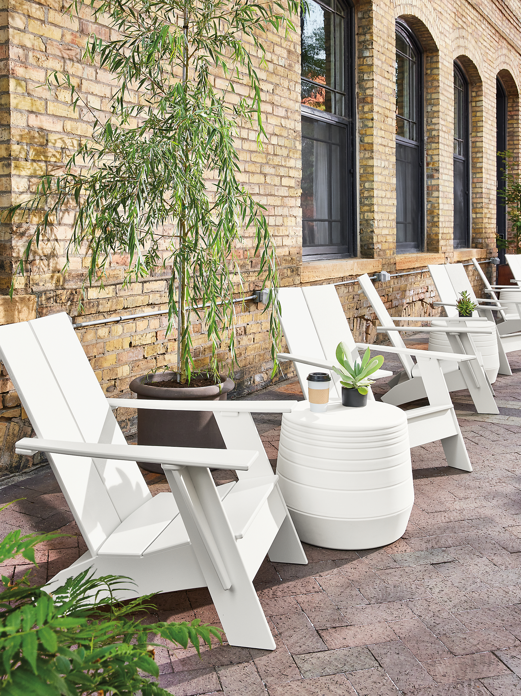 Outdoor space with emmet chairs in white, cusp stools in white, gilyard planters.