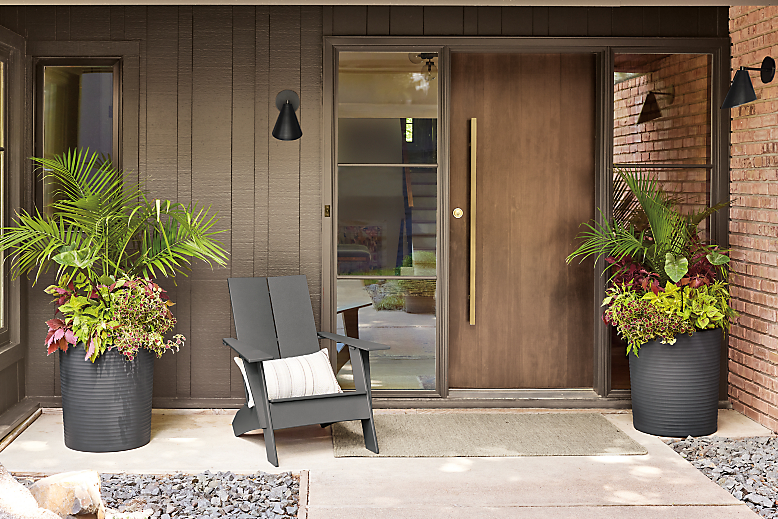 Emmet outdoor lounge chair, two furrow round planters in grey and two Gardner wall sconces on front porch.