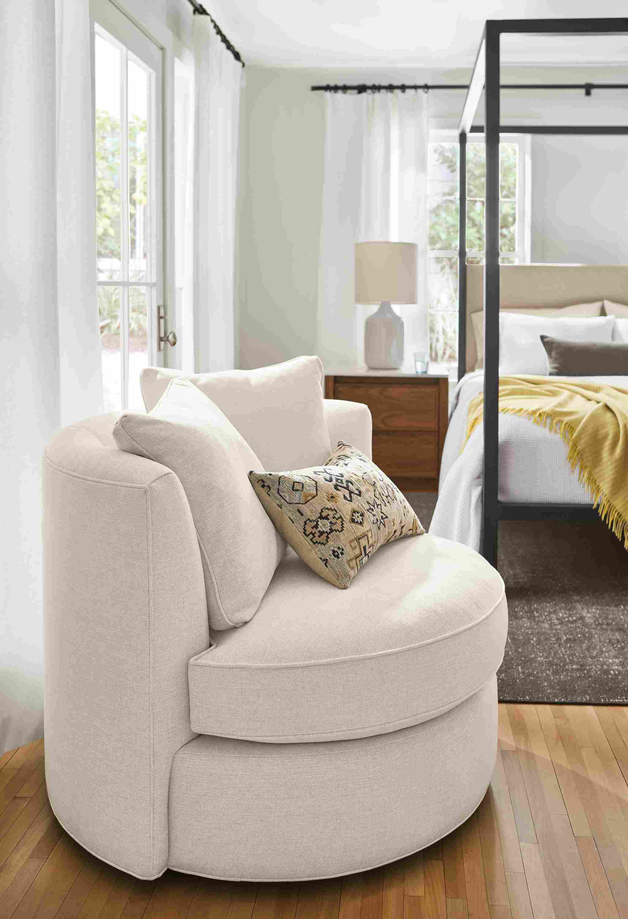 detail of Eos swivel chair in sumner ivory in bedroom.