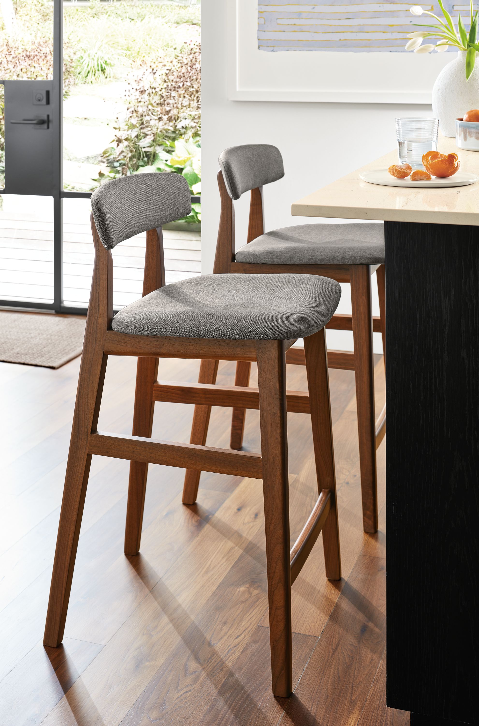 Counter stool in Laila grey fabric with walnut frame