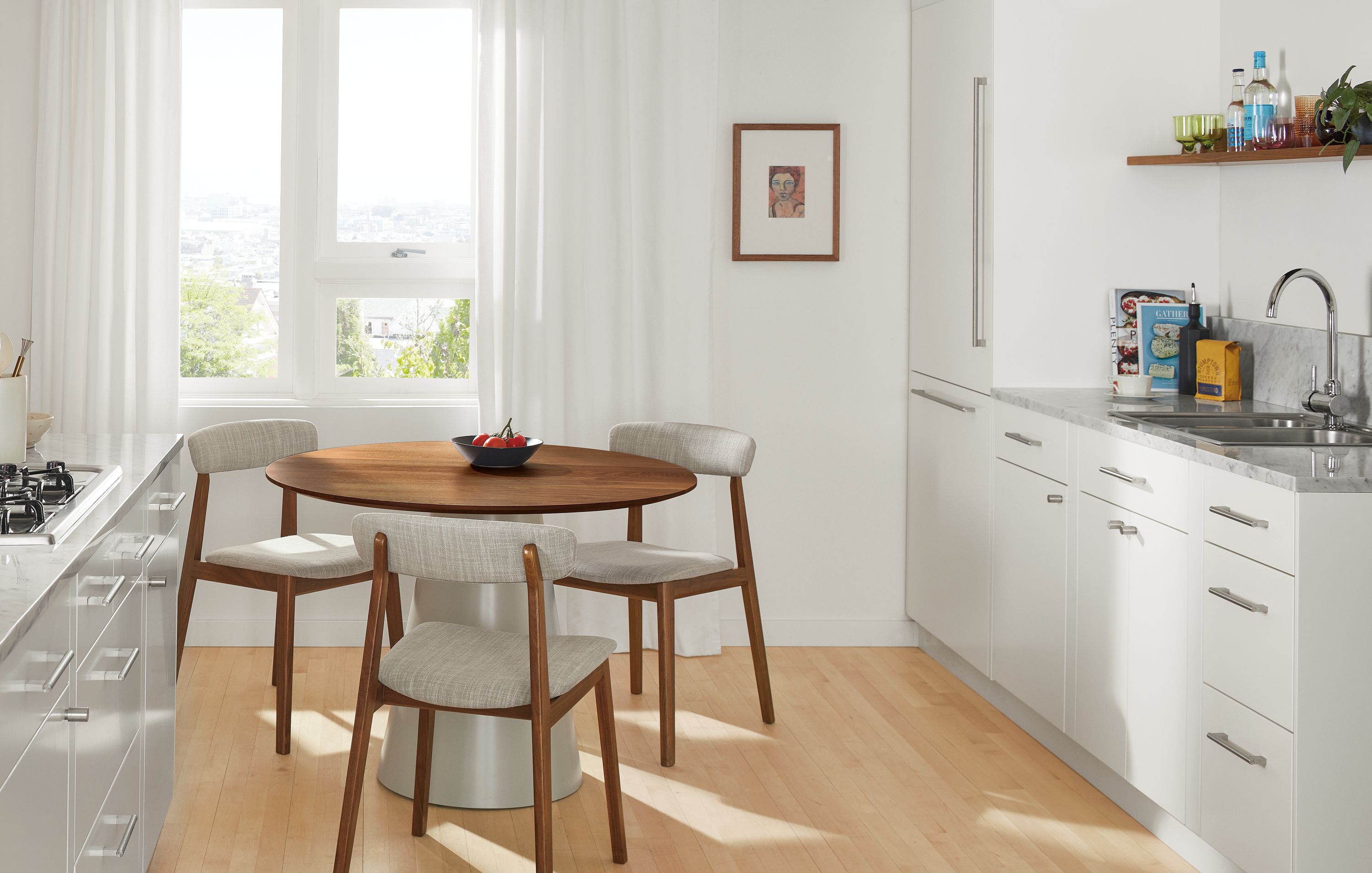 detail of errol side chairs in walnut and fabric at decker round table with walnut top