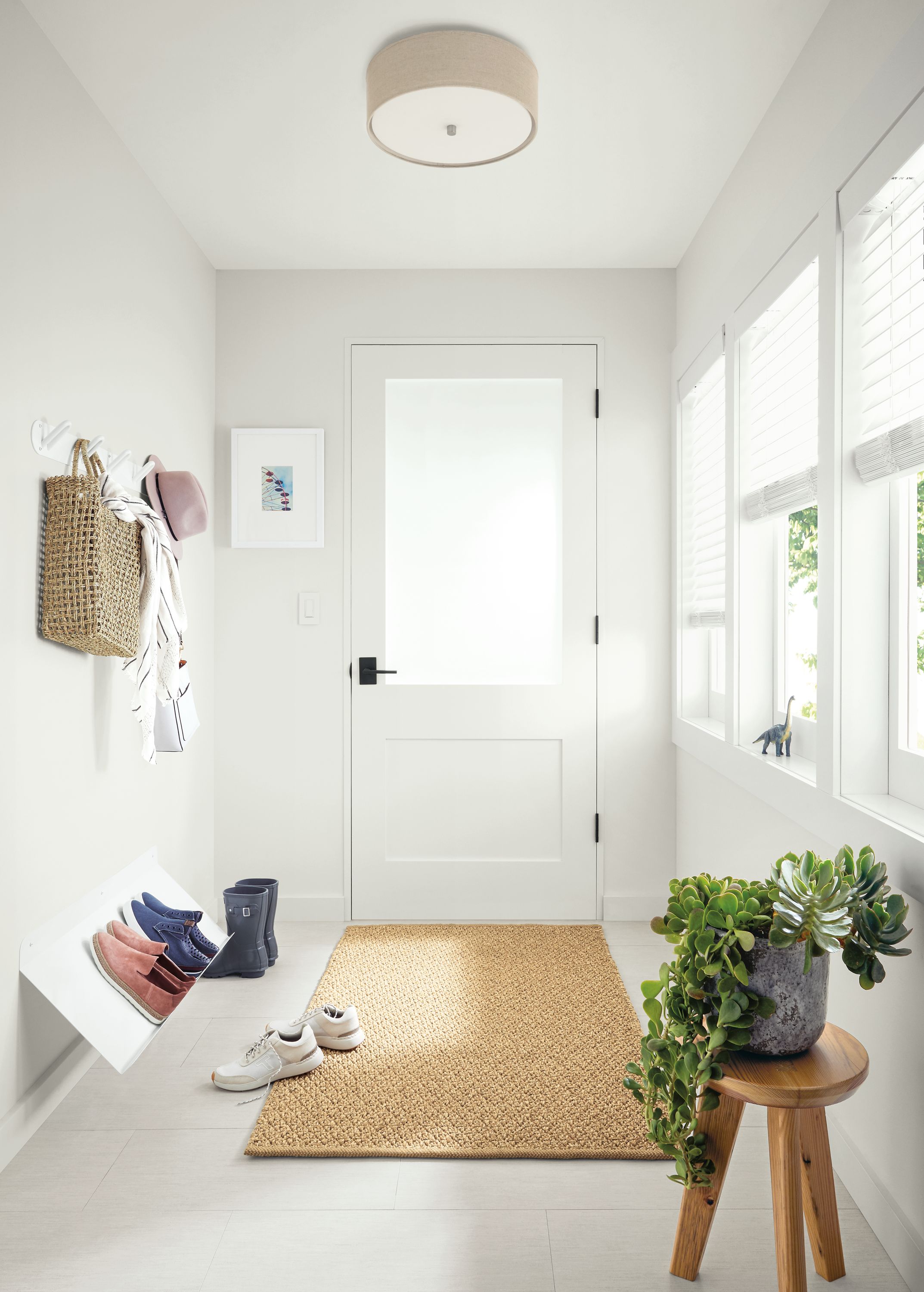 Detail of Esker shoe rack in white powdercoat in entryway with Essence rug.